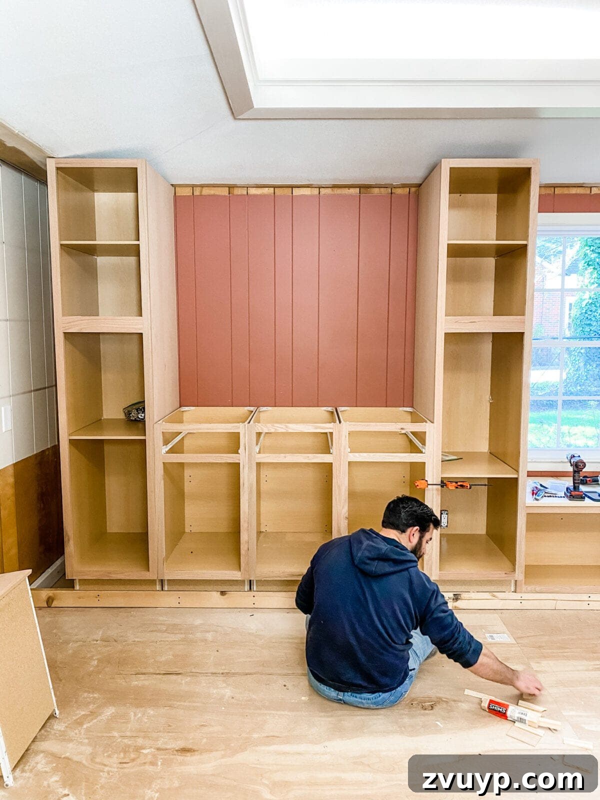 DIY Custom Built-In Storage and Window Nook 19 Tall pantry cabinets being installed and secured on the sides of the window seat