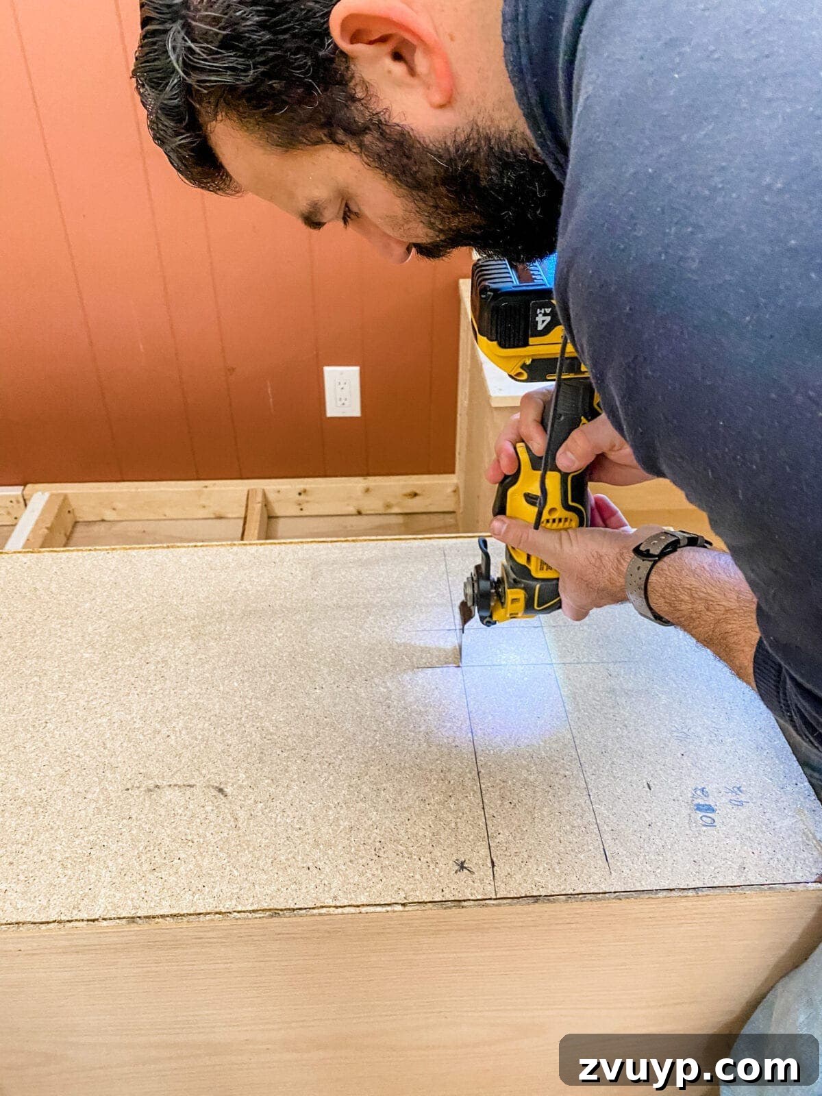 DIY Custom Built-In Storage and Window Nook 20 An oscillating multi-tool used to cut an opening for an electrical outlet in the back of a cabinet