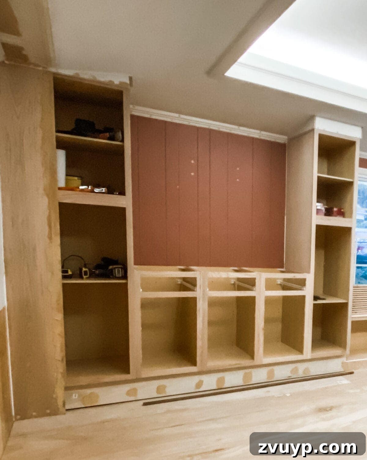 DIY Custom Built-In Storage and Window Nook 28 2x4 framing and poplar board trim applied to the side of the built-in cabinets to integrate them with the wall