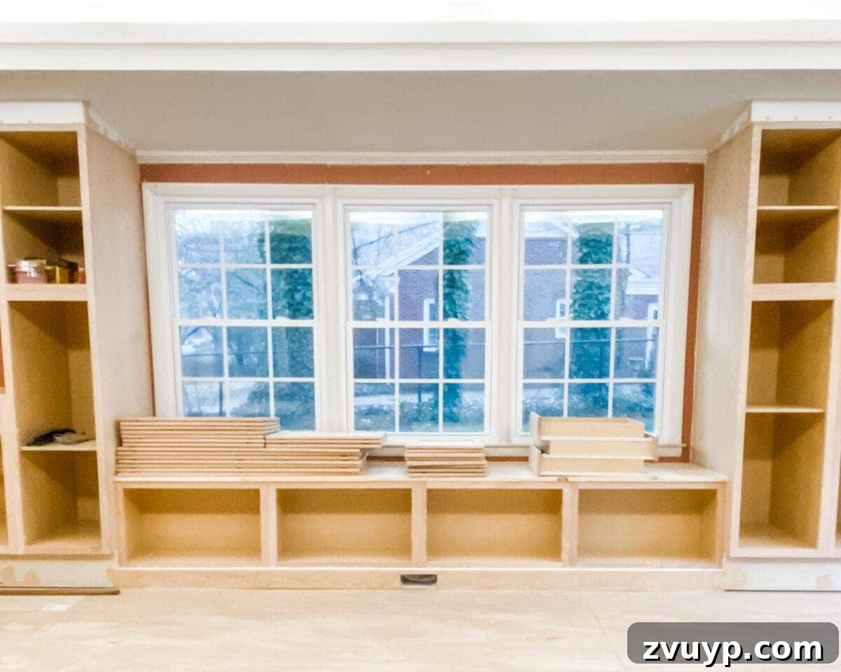 DIY Custom Built-In Storage and Window Nook 29 1x8 pine board attached as the toe kick and 1x4 trim applied to the top of the built-in cabinets