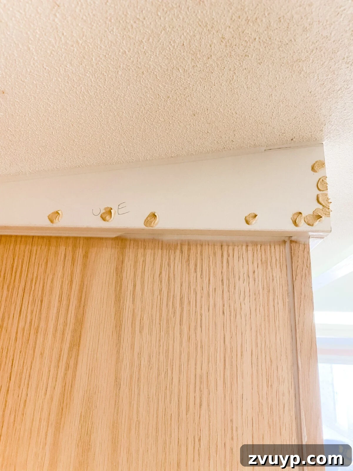 DIY Custom Built-In Storage and Window Nook 30 Wood filler applied to nail holes and seams on the built-in cabinet trim