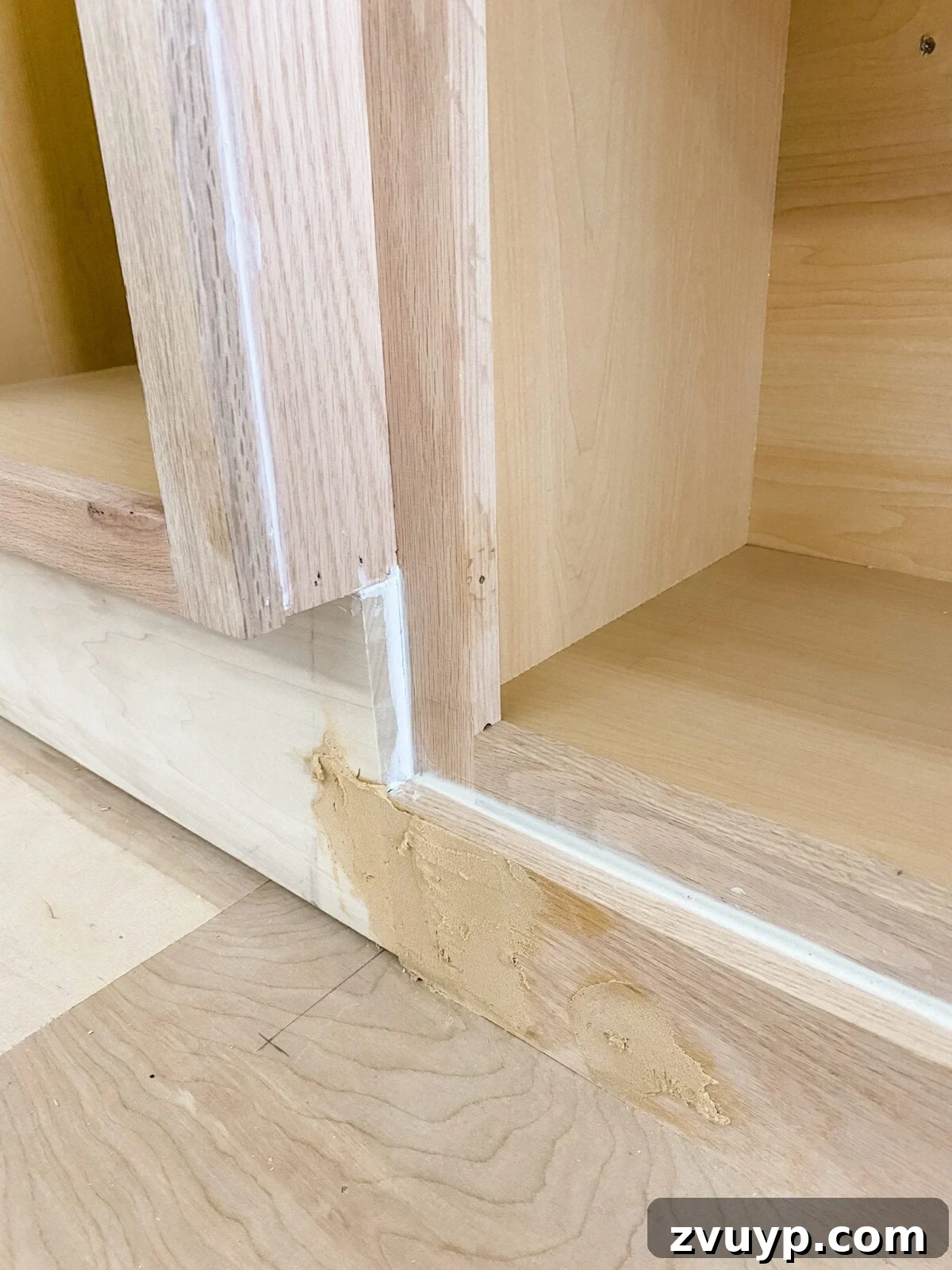 DIY Custom Built-In Storage and Window Nook 31 Caulk applied to seal gaps between cabinet trim and walls for a smooth finish