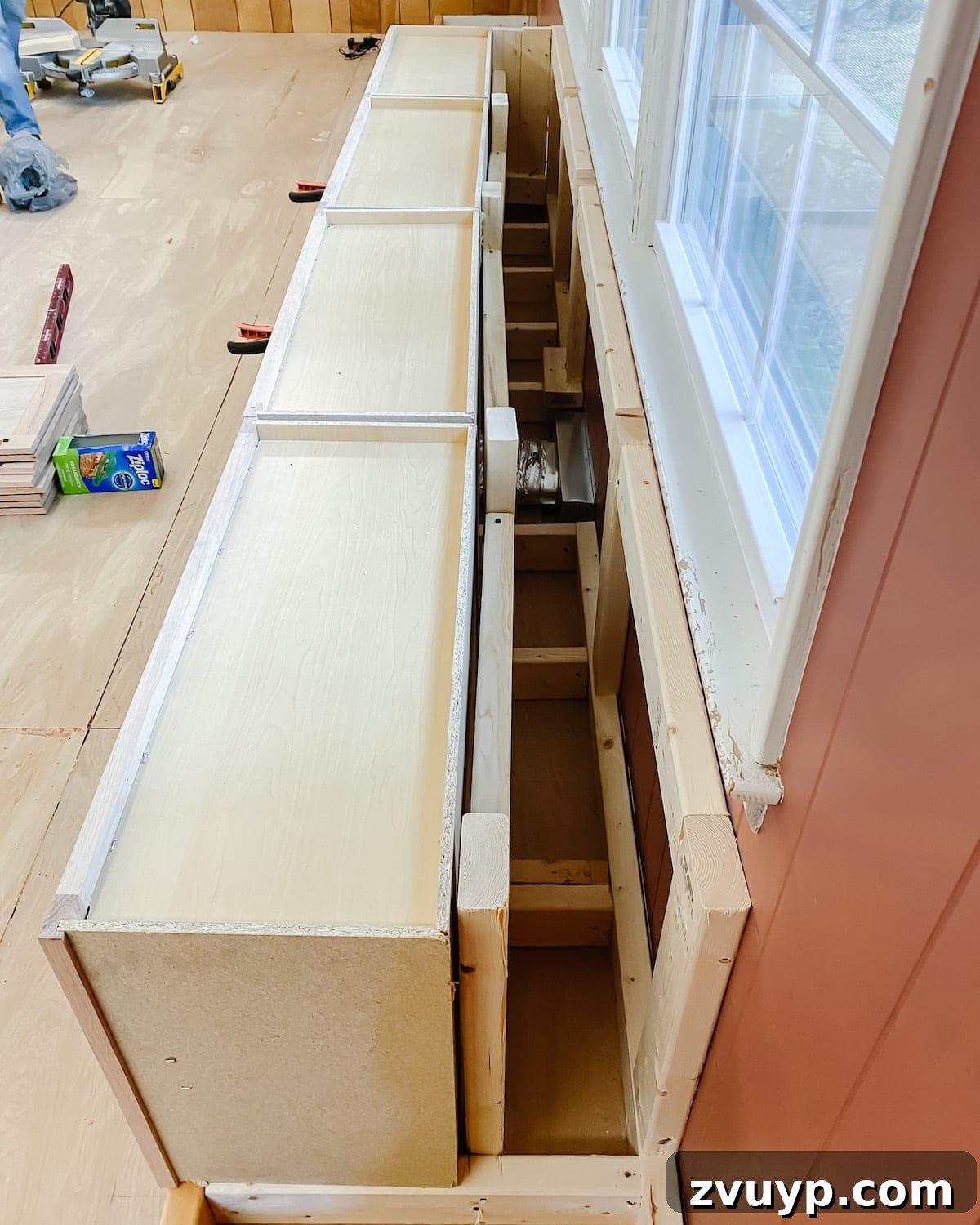 DIY Custom Built-In Storage and Window Nook 9 Stock refrigerator cabinets placed on the 2x4 base, forming the window seat structure
