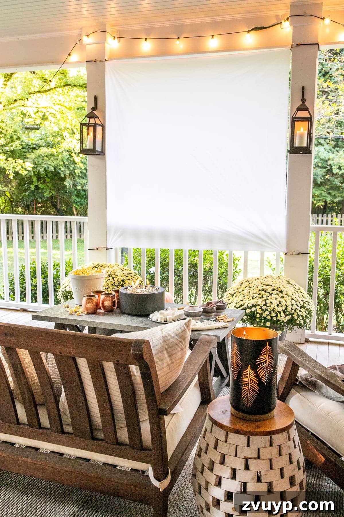 10 Spring DIY Projects for an Outdoor Oasis 5 Cozy outdoor movie night setup with a projection screen and s'mores table on a decorated porch.