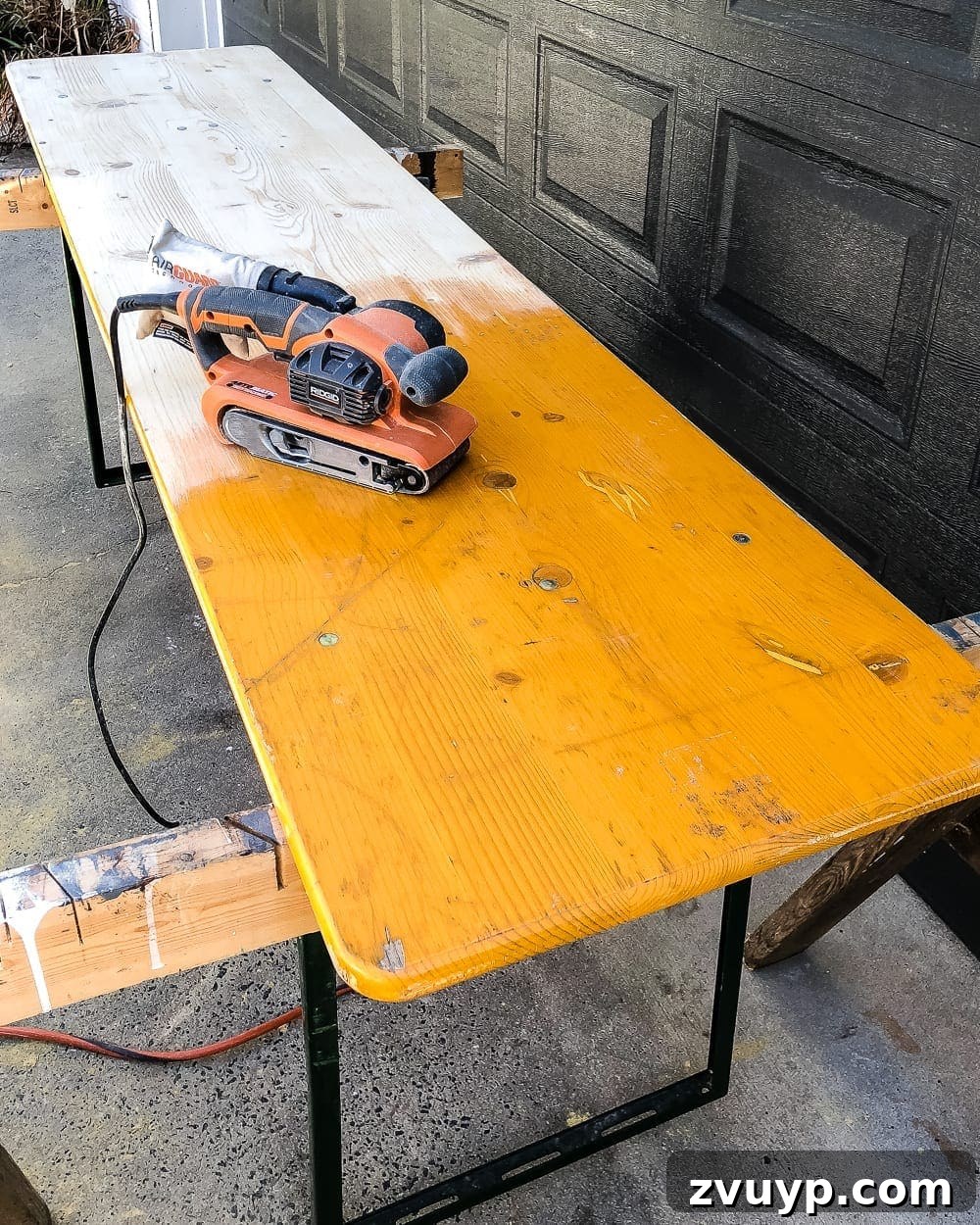 Brewing a Backyard Haven: DIY from Neglect 3 sanding down a folding table for refinishing