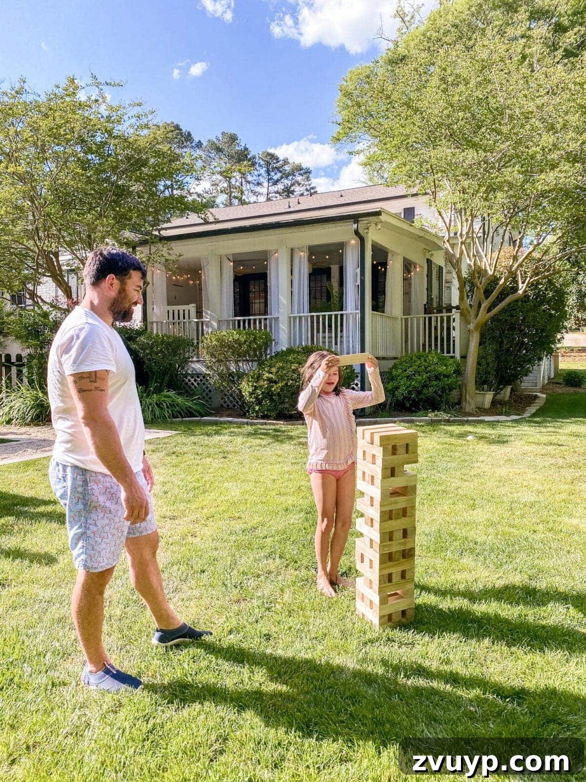 Crowd-Pleasing Yard Games for Every Backyard Cookout 6 father and daughter playing backyard Giant Jenga yard game