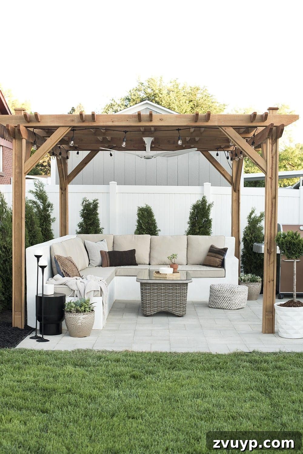 7 Pool Cabana Ideas for Your Backyard Oasis 9 Inviting backyard cabana showcasing the warmth of stained wood against a contrasting white fence, creating a cozy and natural outdoor space.
