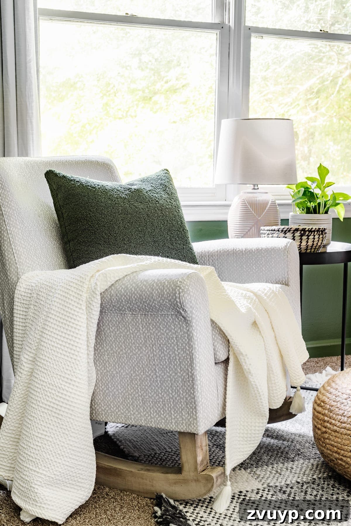 Little Explorer's Woodland Nursery Transformation 11 A cozy nursery rocking chair paired with a practical side table, offering comfort and convenience for parents.