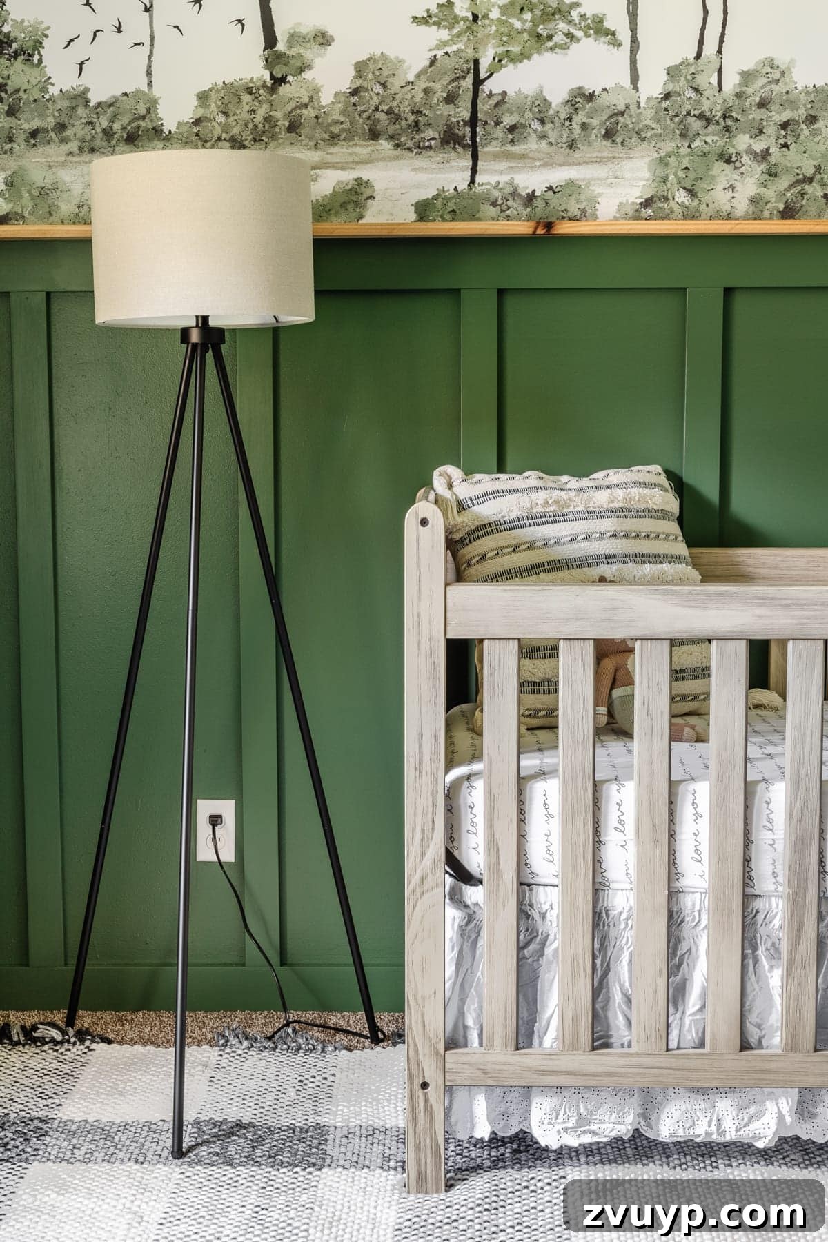 Little Explorer's Woodland Nursery Transformation 15 A woodland theme baby boy nursery featuring a stylish floor lamp, a natural wood crib, a cozy plaid rug, and a captivating wall mural.