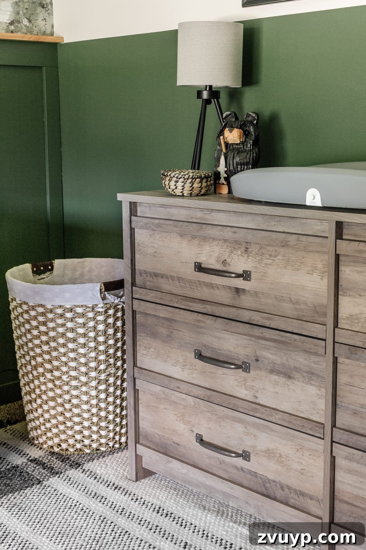 Little Explorer's Woodland Nursery Transformation 8 A boy nursery featuring a weathered wood dresser, practical storage solutions, and a soft ambient lamp for late-night changes.
