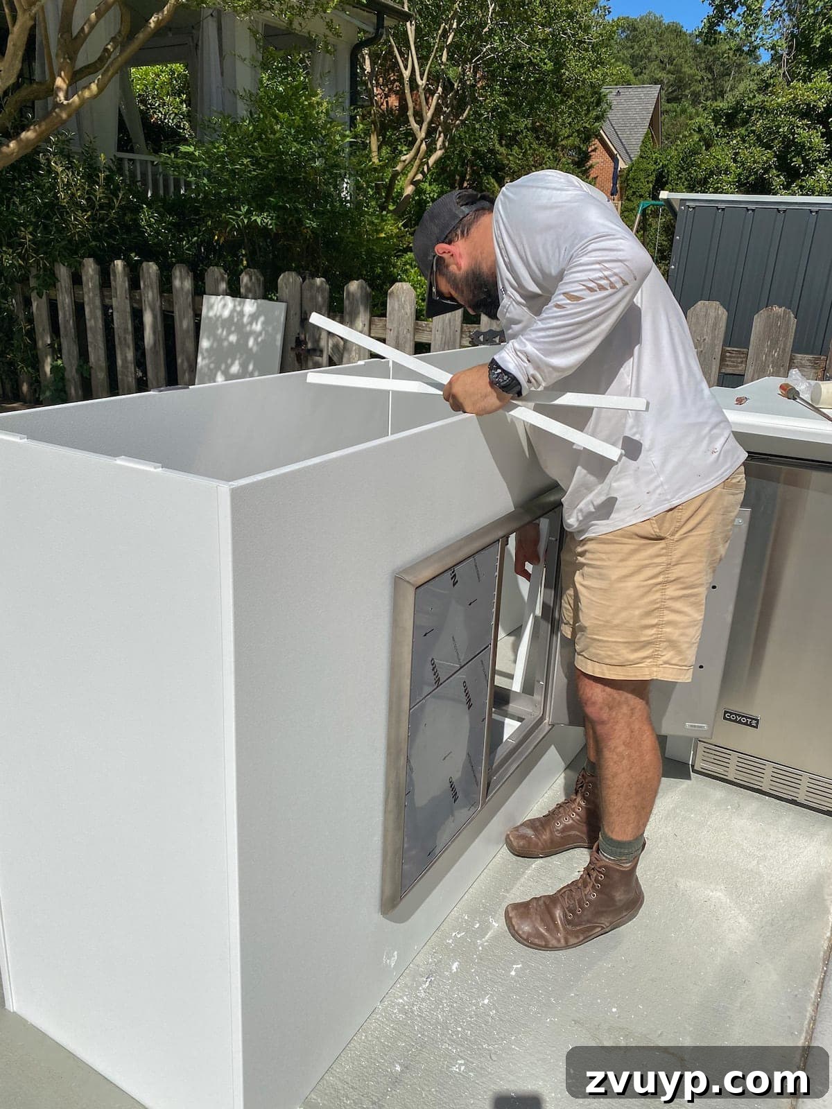 Effortless DIY Outdoor Kitchen Kit Build: Essential Tips 12 Two people effortlessly adding the bar island to the modular outdoor kitchen setup, extending the functional space.