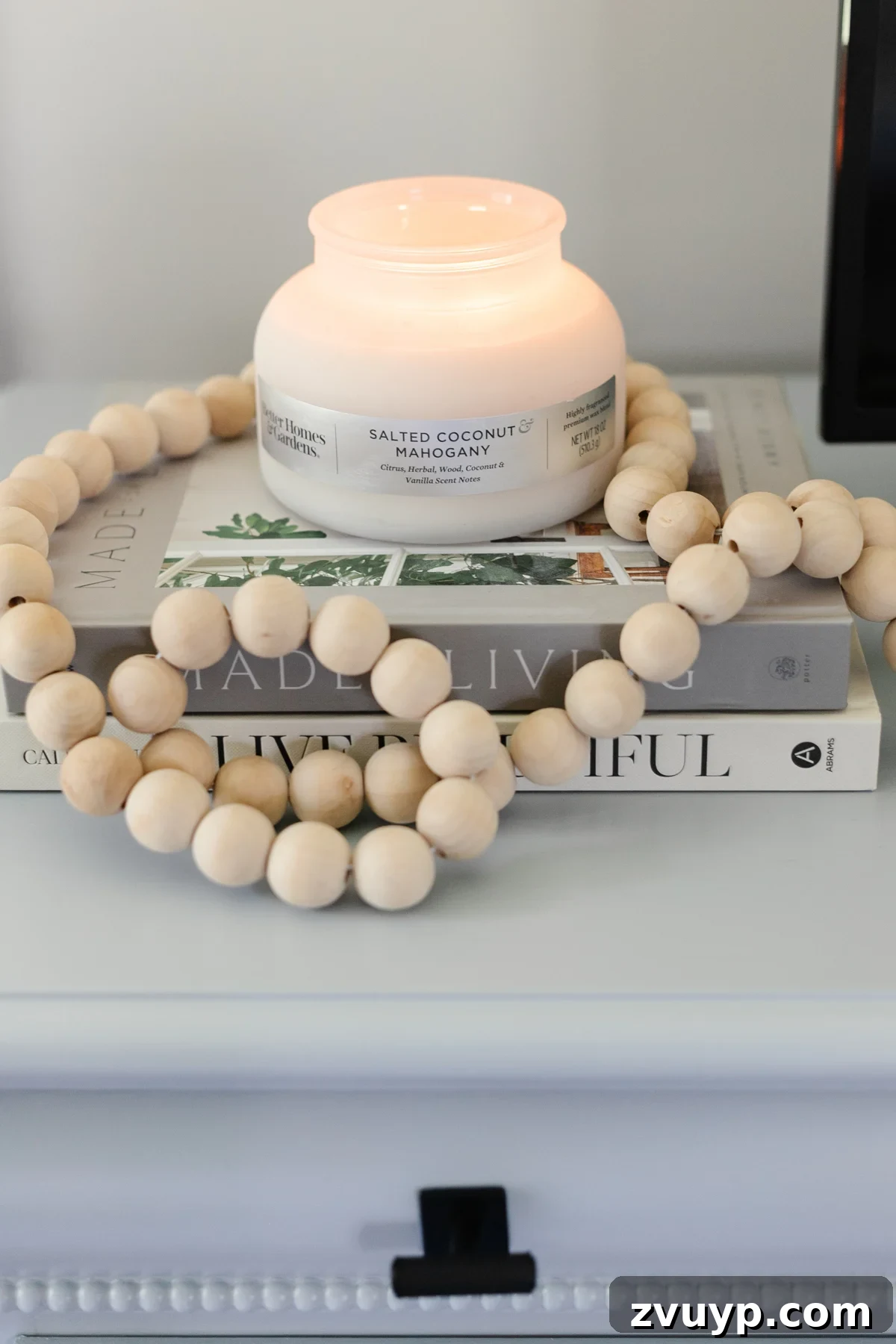 Small Space, Big Impact: 10 Bedroom Design Secrets 11 candle with wooden beads and book stack on dresser