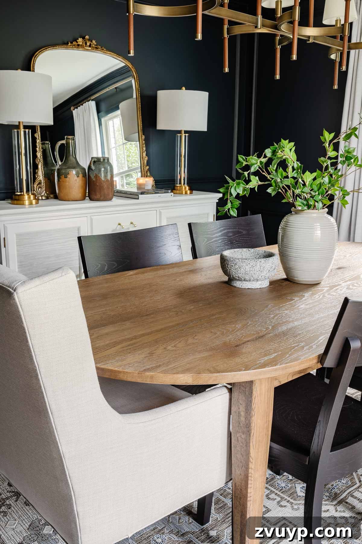 Bassett BenchMade Classic Modern Dining Refined 4 Classic modern dining room featuring a wood oval table, black chairs, navy walls, linen curtains, and a French mirror