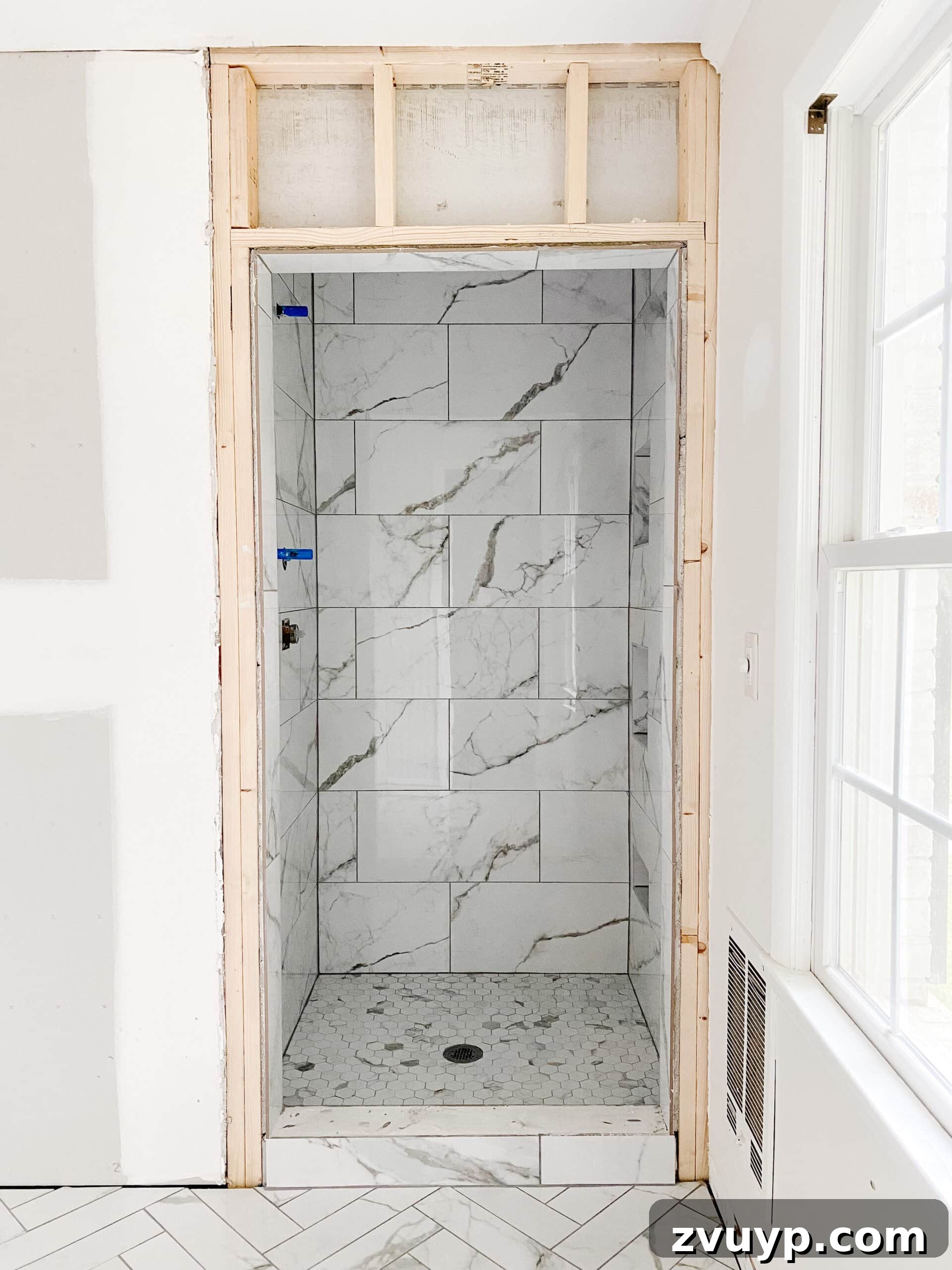 Faux Marble Herringbone: Our Shower Transformation Unfolds 5 Newly renovated shower with realistic faux marble porcelain tiles and a sleek, modern aesthetic.