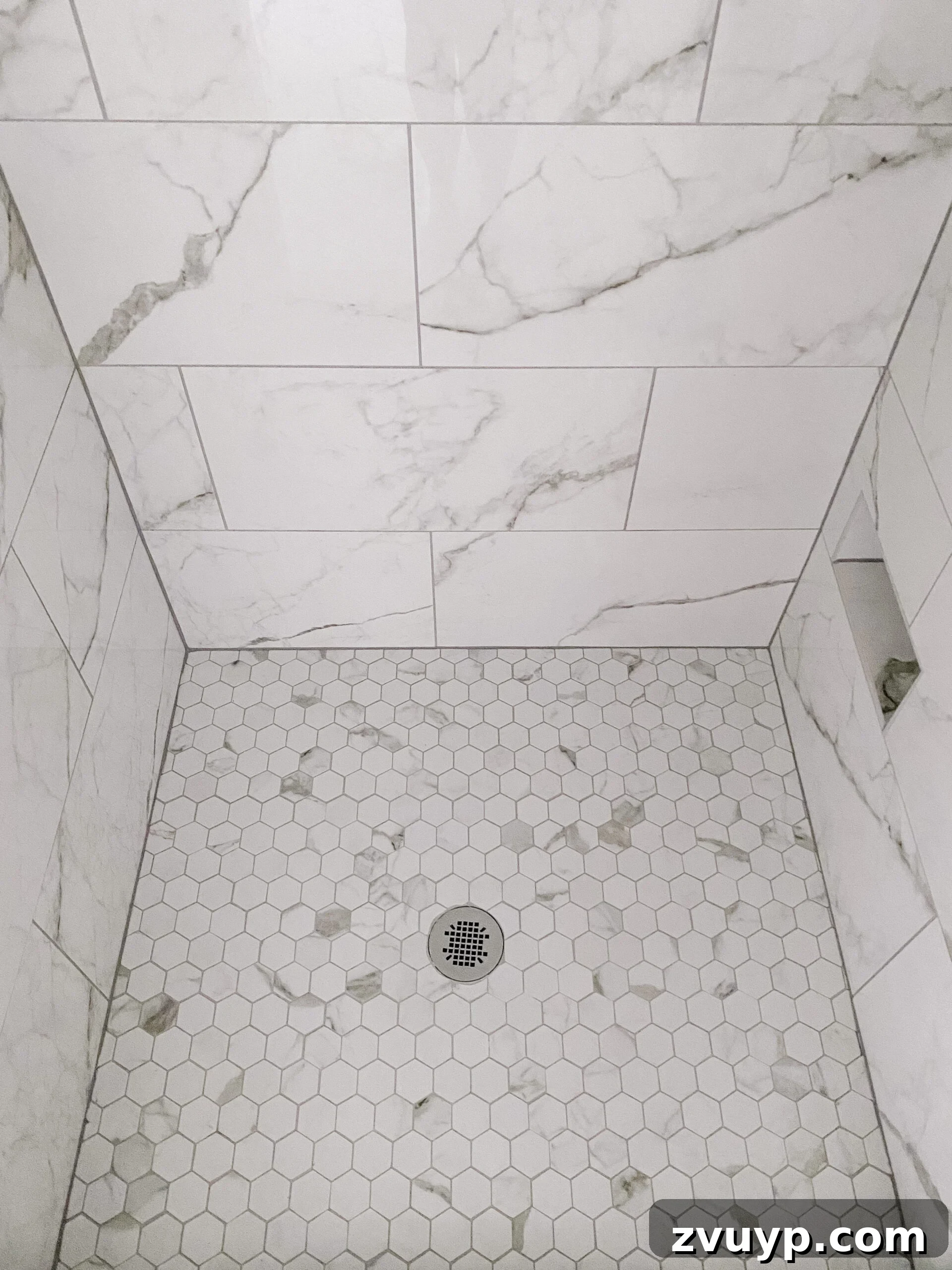 Faux Marble Herringbone: Our Shower Transformation Unfolds 10 Close-up of the elegant faux marble hexagon tile shower floor with complementary gray grout.