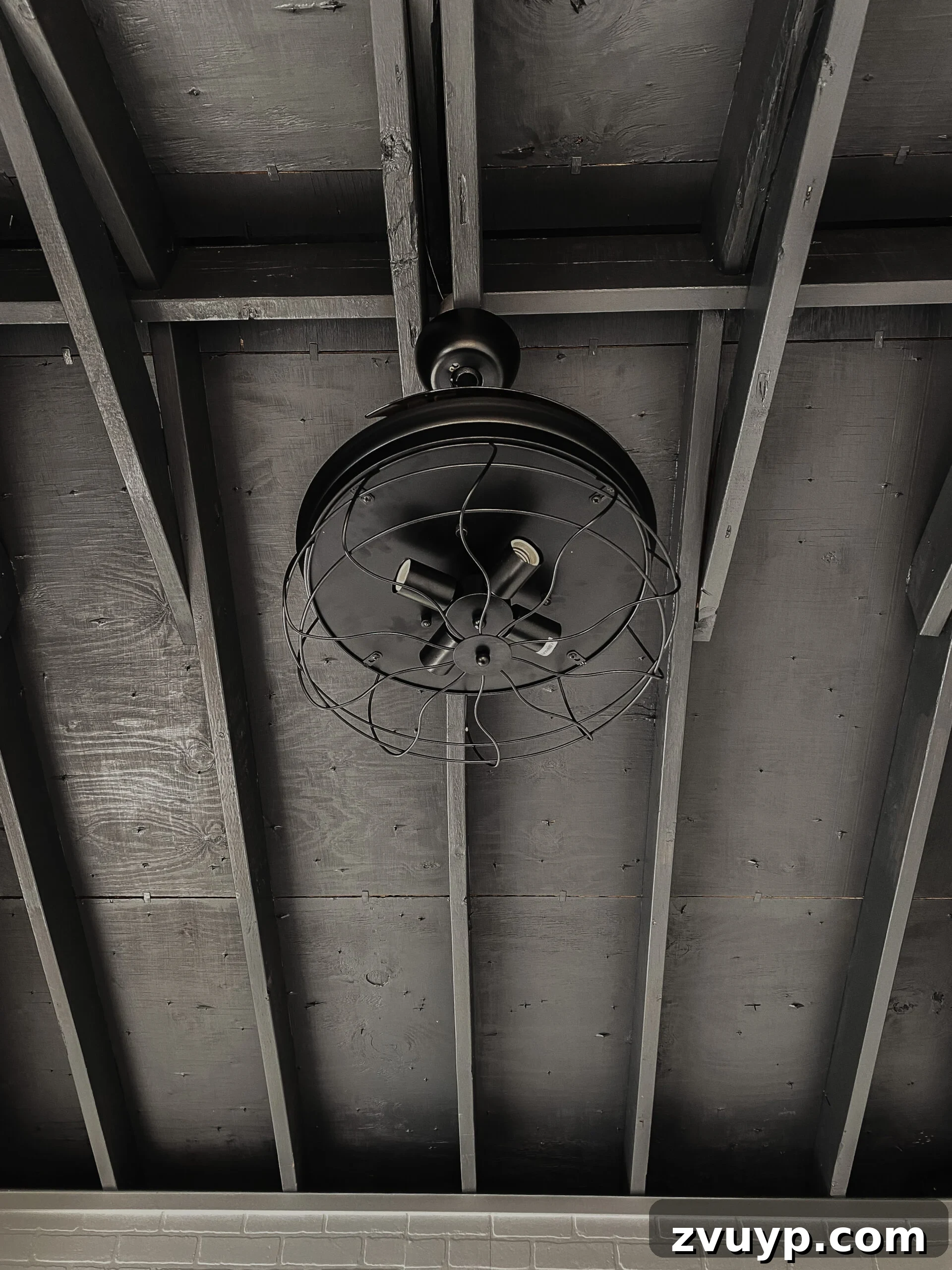 Transform Your Gym Shed with DIY Faux Brick Walls 18 A black ceiling fan with sleek, retractable blades installed against the dark ceiling of the gym shed, enhancing both style and air circulation.