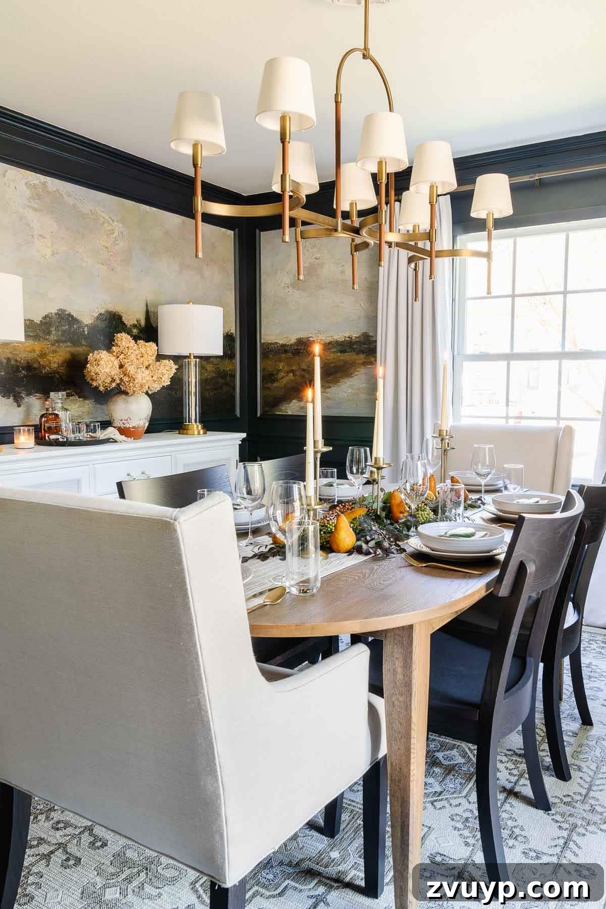 Thanksgiving decor in the dining room with candles, navy walls, and leaves