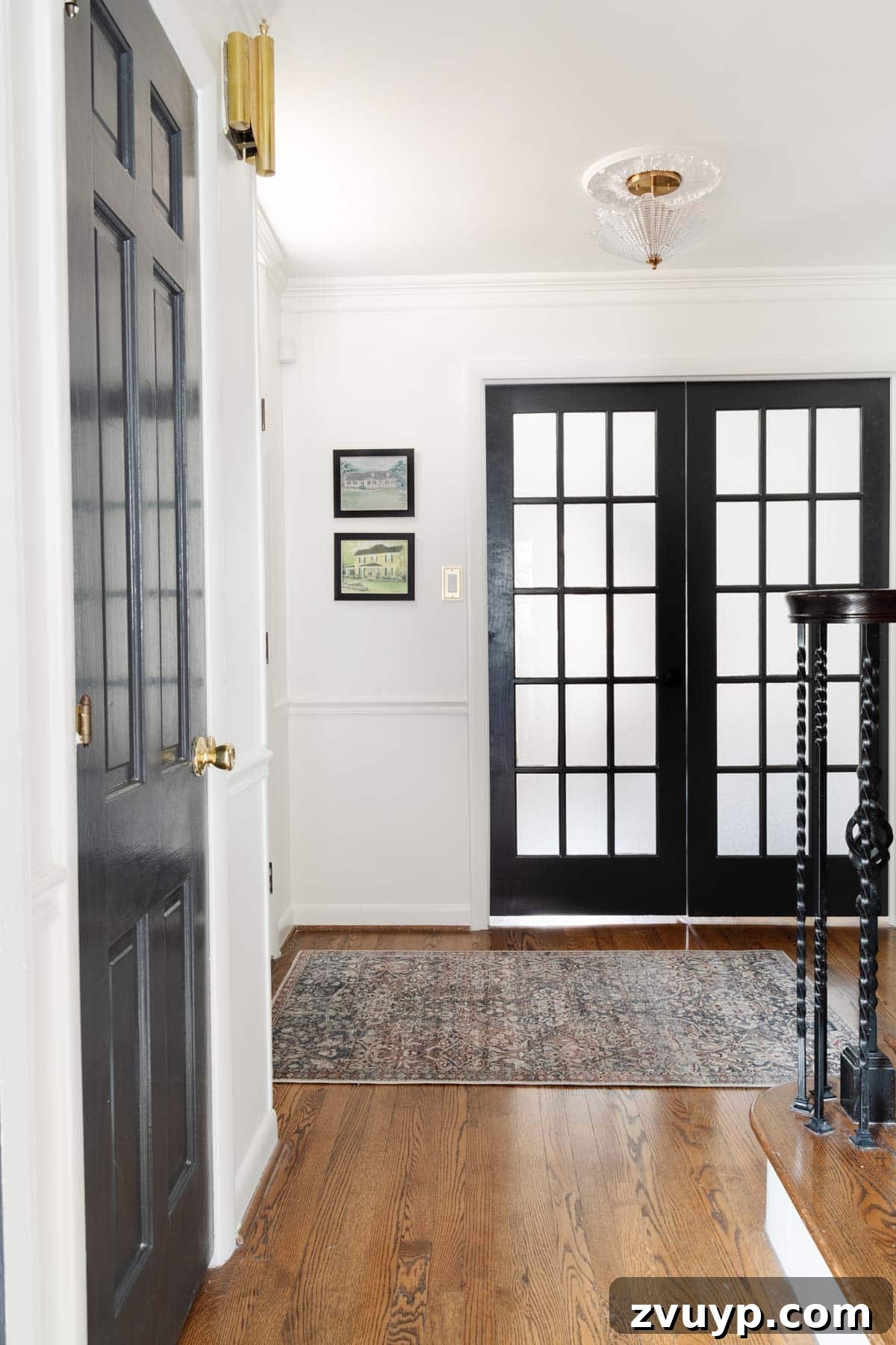 Vintage Meets Modern Foyer Makeover 11 Elegant house portrait art displayed beside a front door in a foyer, flanked by double French doors leading to a home office, adding a personal and sentimental touch to the decor.