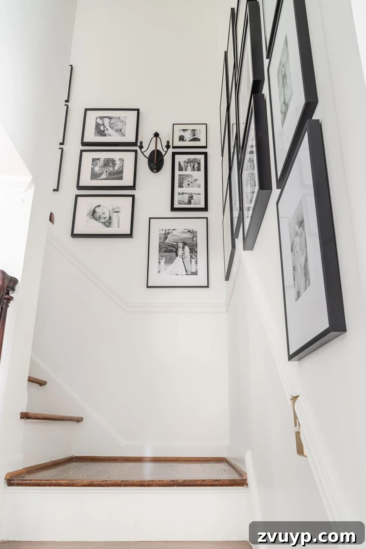 Vintage Meets Modern Foyer Makeover 15 Detailed view of a gallery wall composed of black and white family pictures, arranged thoughtfully to create a cohesive and deeply personal display of cherished memories.
