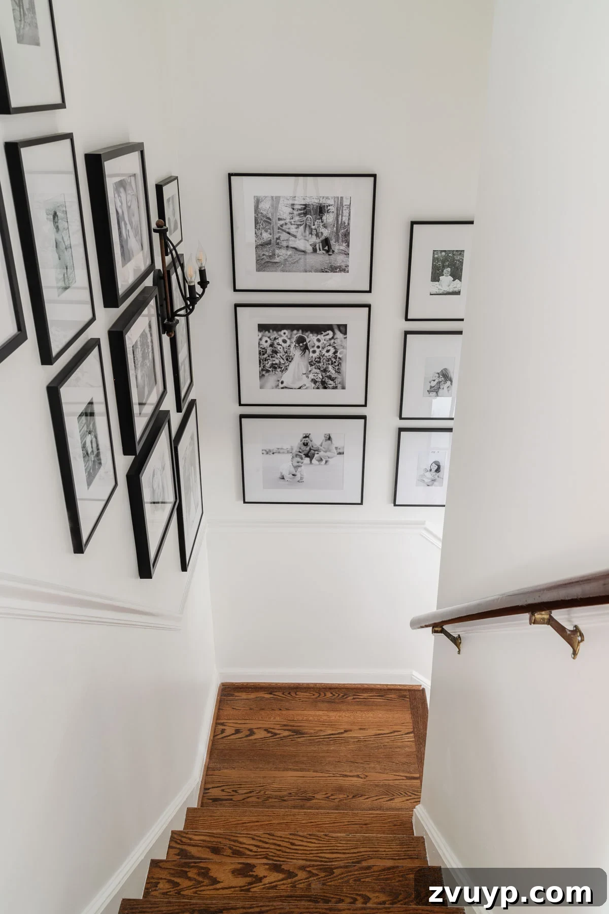 Vintage Meets Modern Foyer Makeover 17 Expansive family stairway gallery wall showcasing numerous framed black and white photographs, creating a compelling visual narrative that personalizes the entryway.