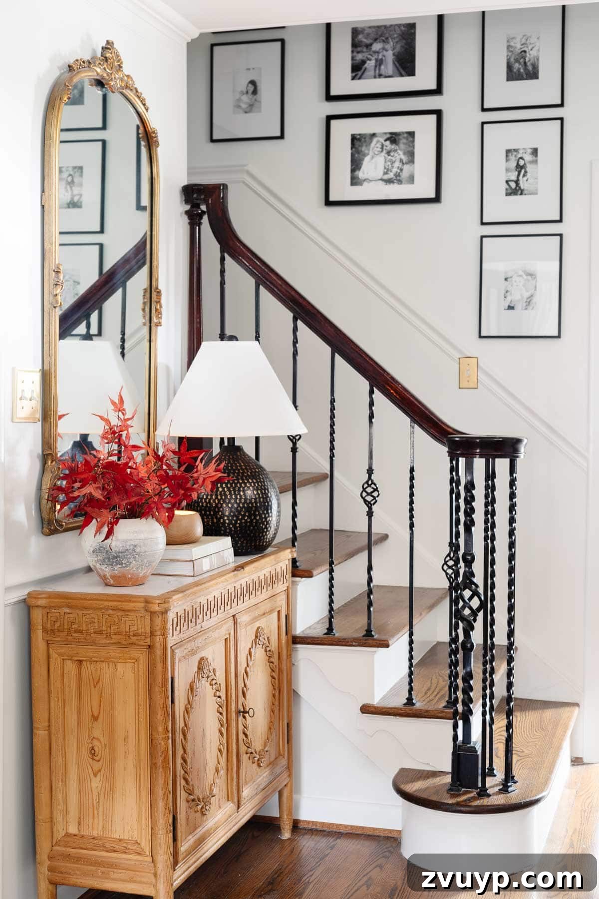 Vintage Meets Modern Foyer Makeover 18 Warm and inviting foyer table styled with seasonal fall leaves in a vase, complemented by an elegant mirror and ambient lighting, creating a perfect entryway vignette.