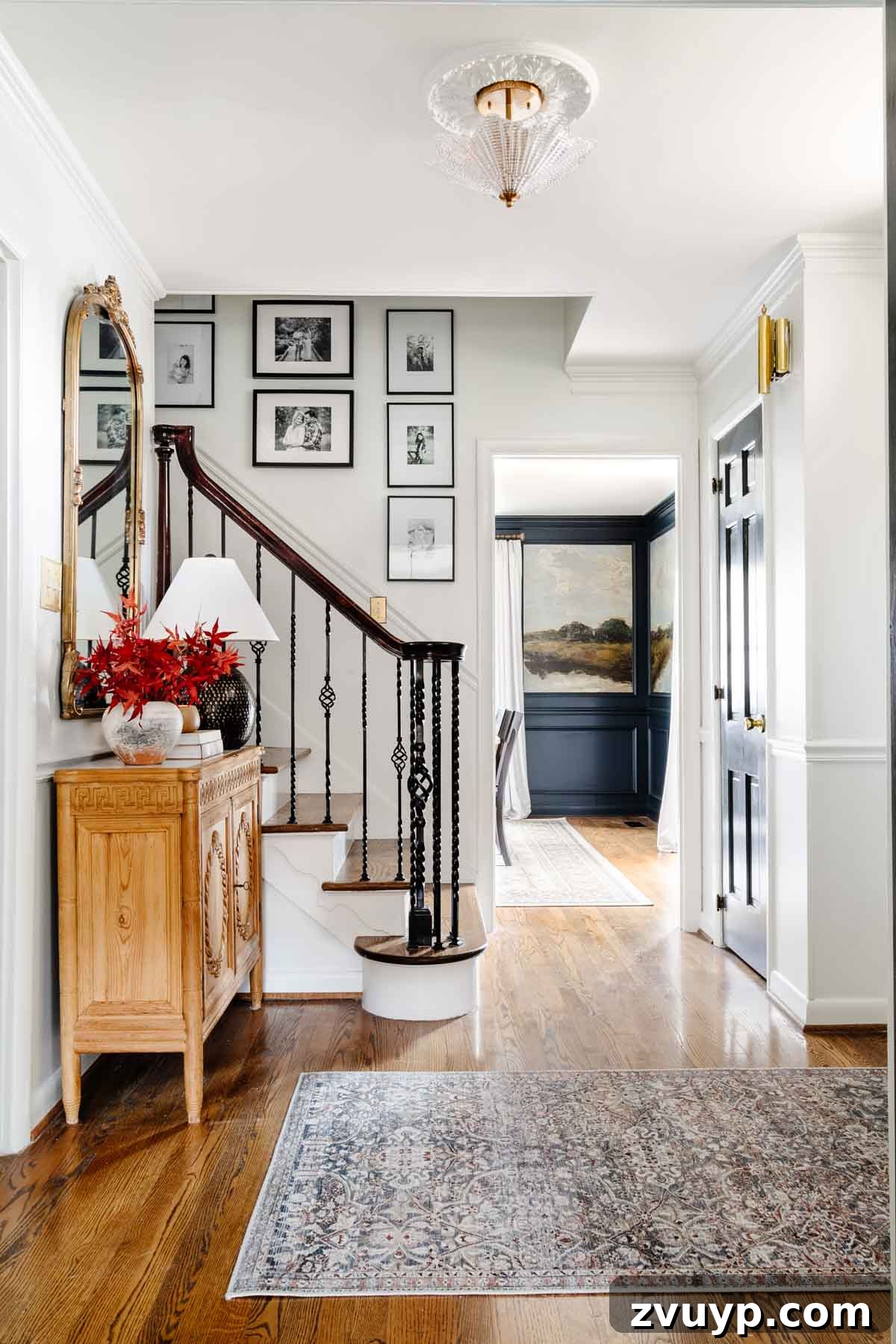 Vintage Meets Modern Foyer Makeover 19 Fully decorated foyer showcasing a striking gallery wall, a stylish entryway table, and a plush rug, perfectly demonstrating how to mix new decor with personal sentimental items.
