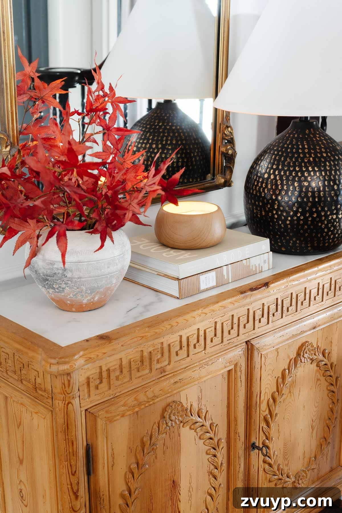 Vintage Meets Modern Foyer Makeover 10 Beautifully styled entryway table featuring a large, ornate mirror, a elegant lamp, and a vase filled with colorful fall foliage, showcasing detailed craftsmanship.