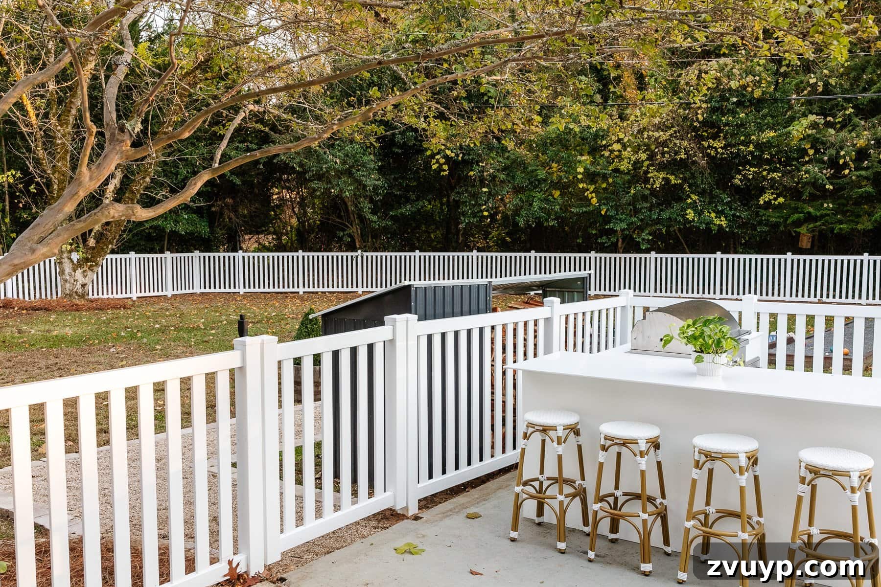 Vinyl Fence Installation Made Easy: Your Ultimate Guide 3 backyard with white vinyl fence and outdoor kitchen