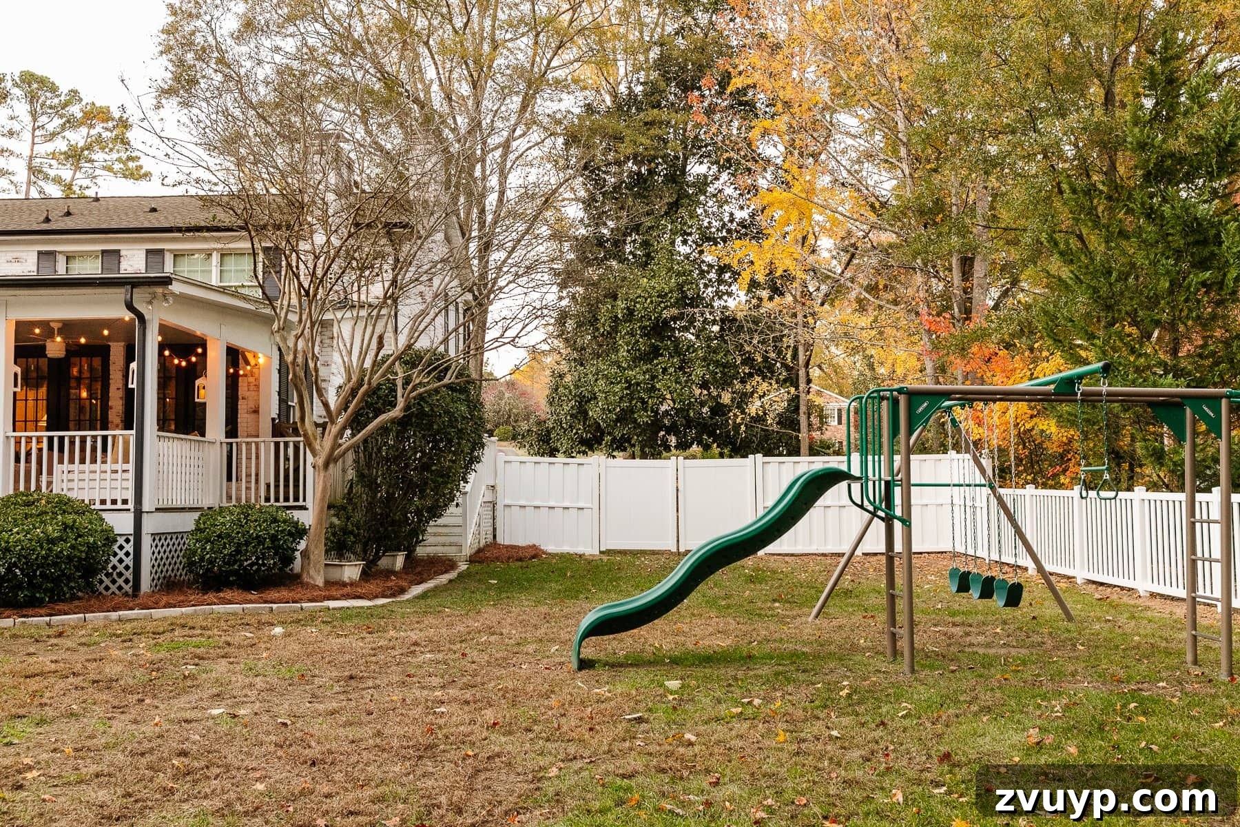 Vinyl Fence Installation Made Easy: Your Ultimate Guide 6 backyard with back porch, playground, and white vinyl fence