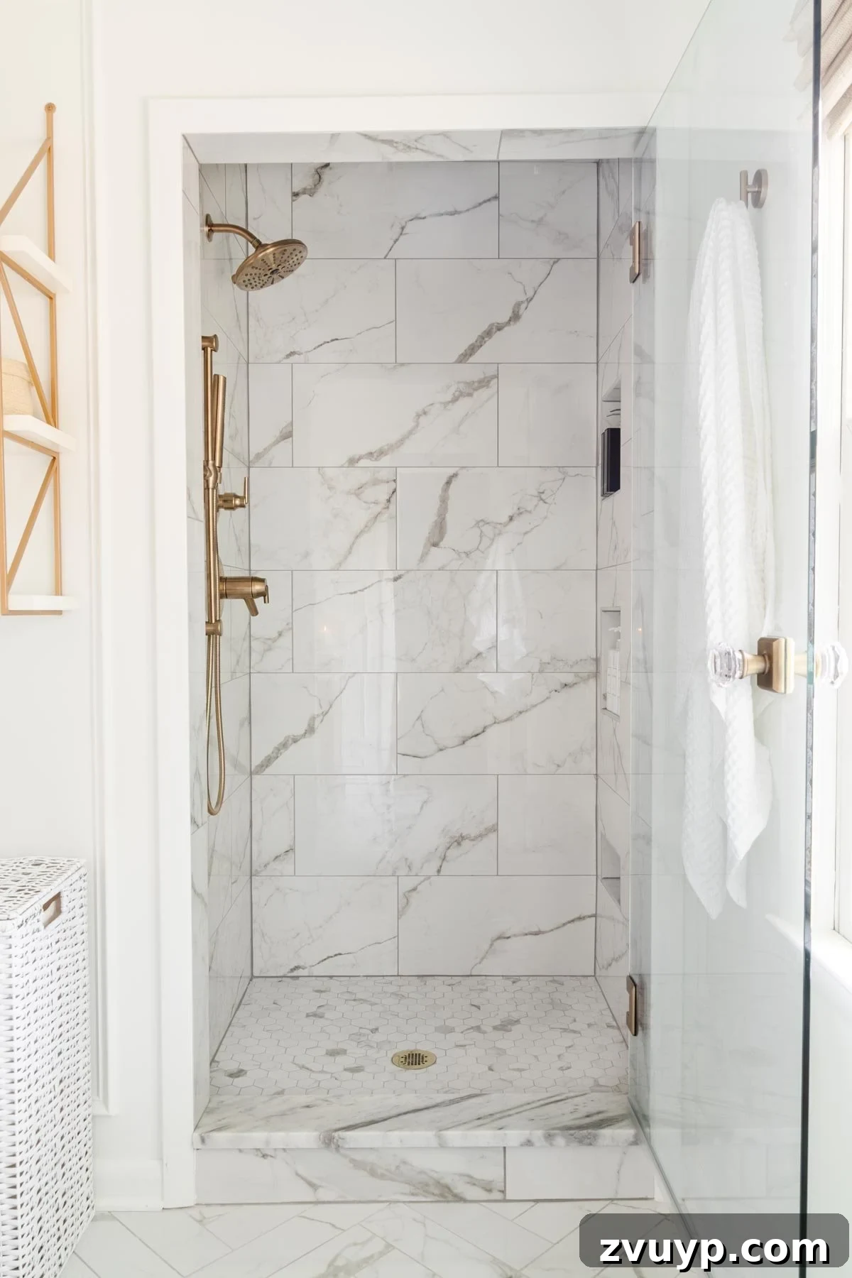 The Perfect Blend: Modern Vintage En Suite Bathroom Tour 15 Small shower interior showcasing beautiful marble-effect tile, a clear glass door, and an elegant shower knob, with gold fixtures