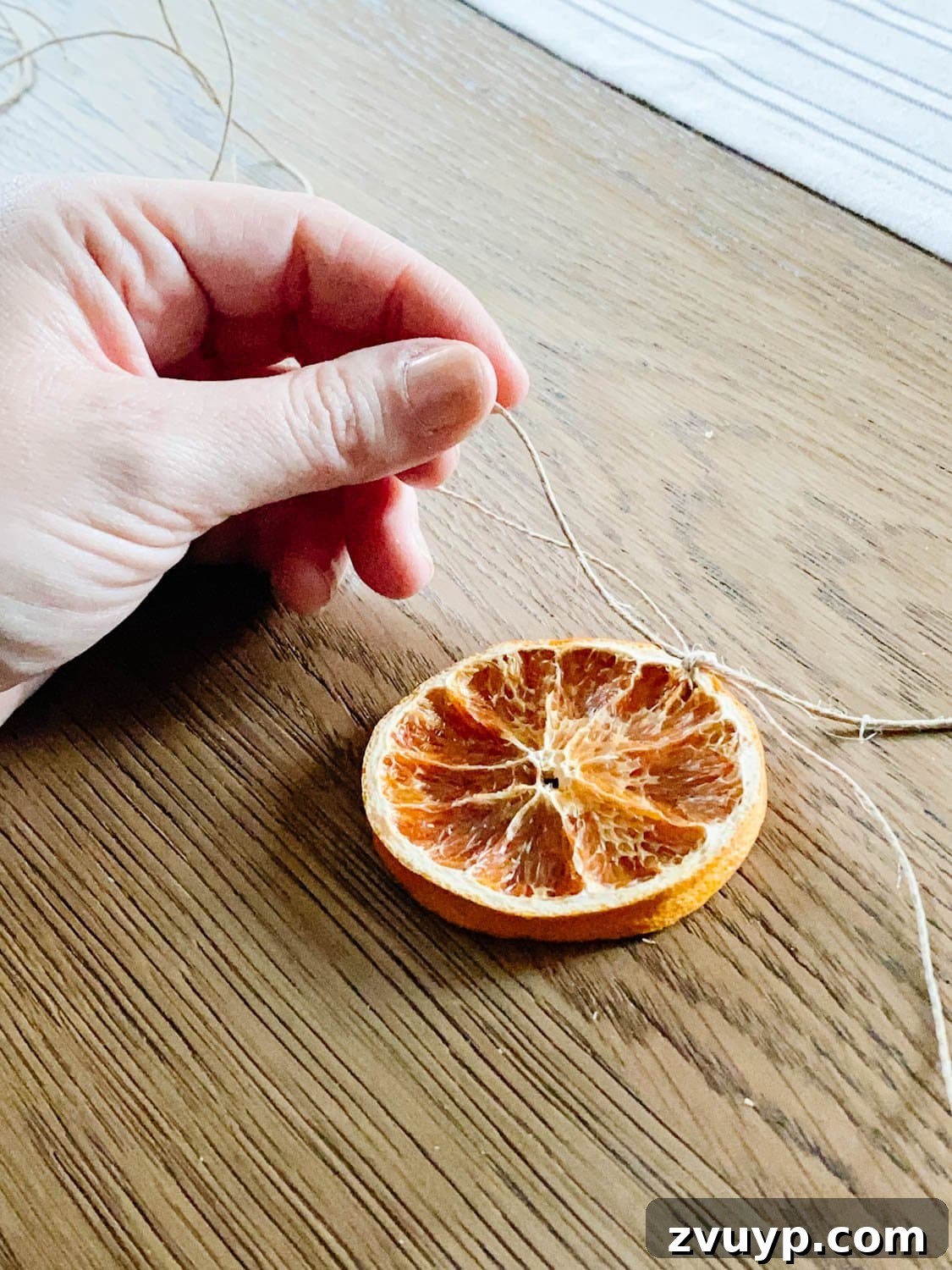 Effortless Homemade Dried Orange Garland 7 how to thread and tie dried orange slices to garland