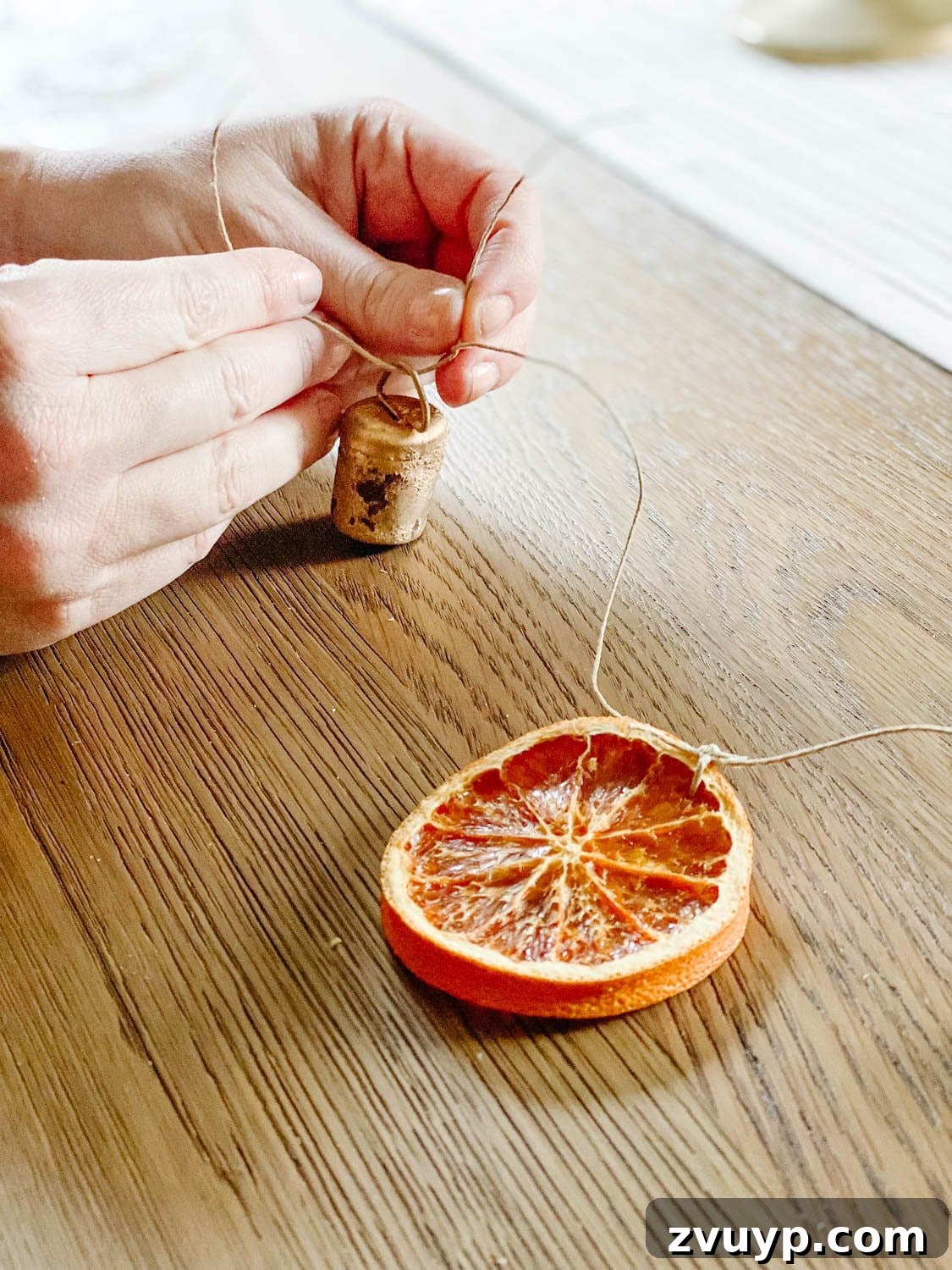 Effortless Homemade Dried Orange Garland 9 adding mini brass bells to garland
