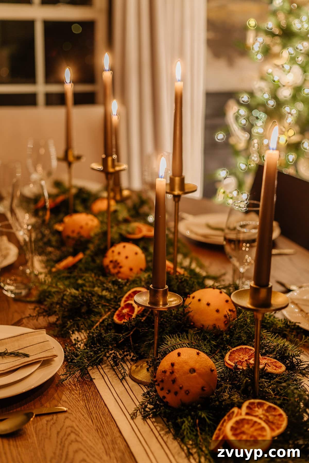 Enchanted Glow Tour 13 Close-up detail of Christmas dining room table decor at night, highlighting specific festive elements and the intimate glow created by candlelight.