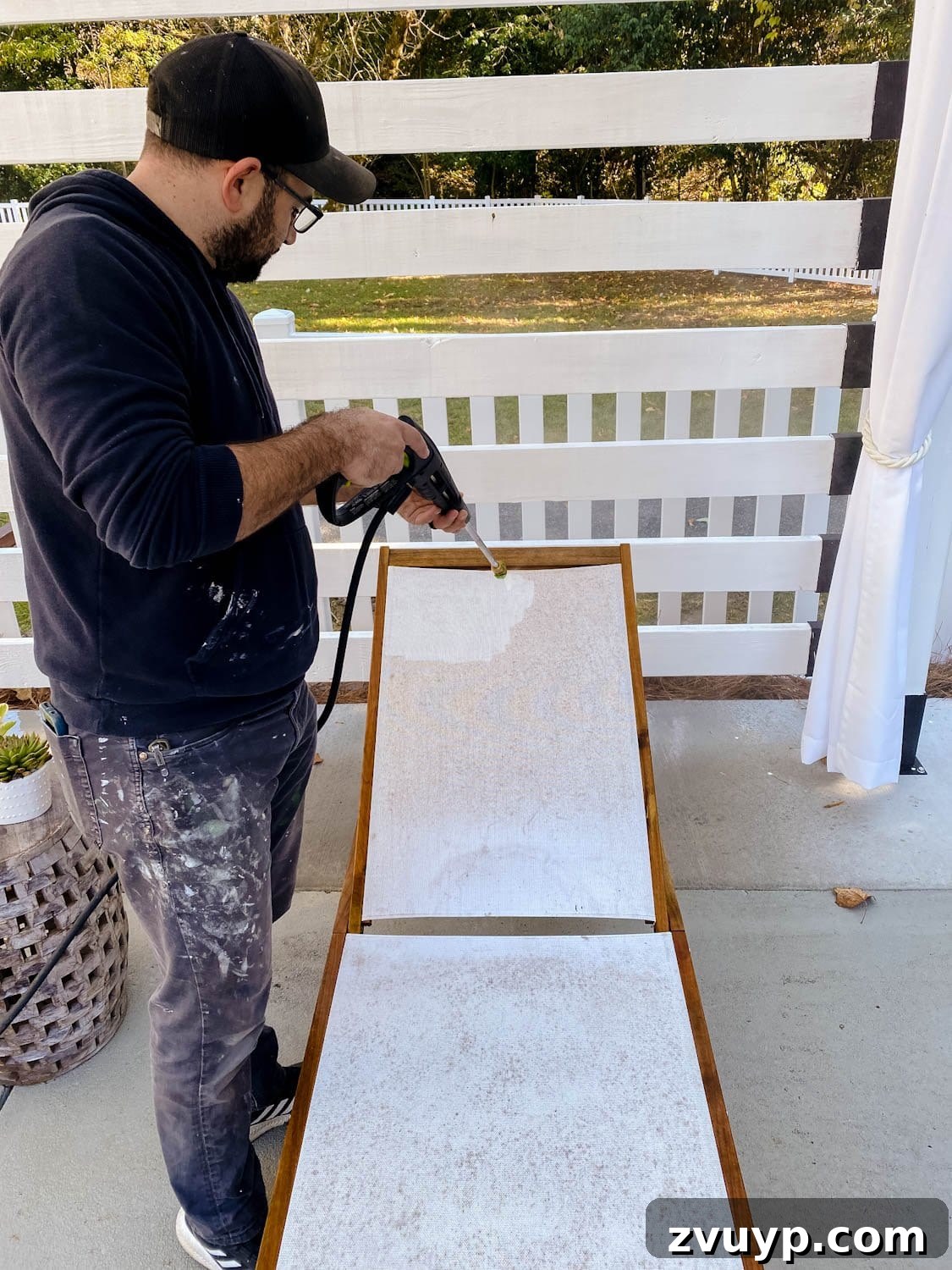 Revive Your Outdoor Oasis: Expert Cleaning for Cushions and Furniture 7 Close-up of cleaning outdoor furniture with a pressure washer, showing mildew spots disappearing.