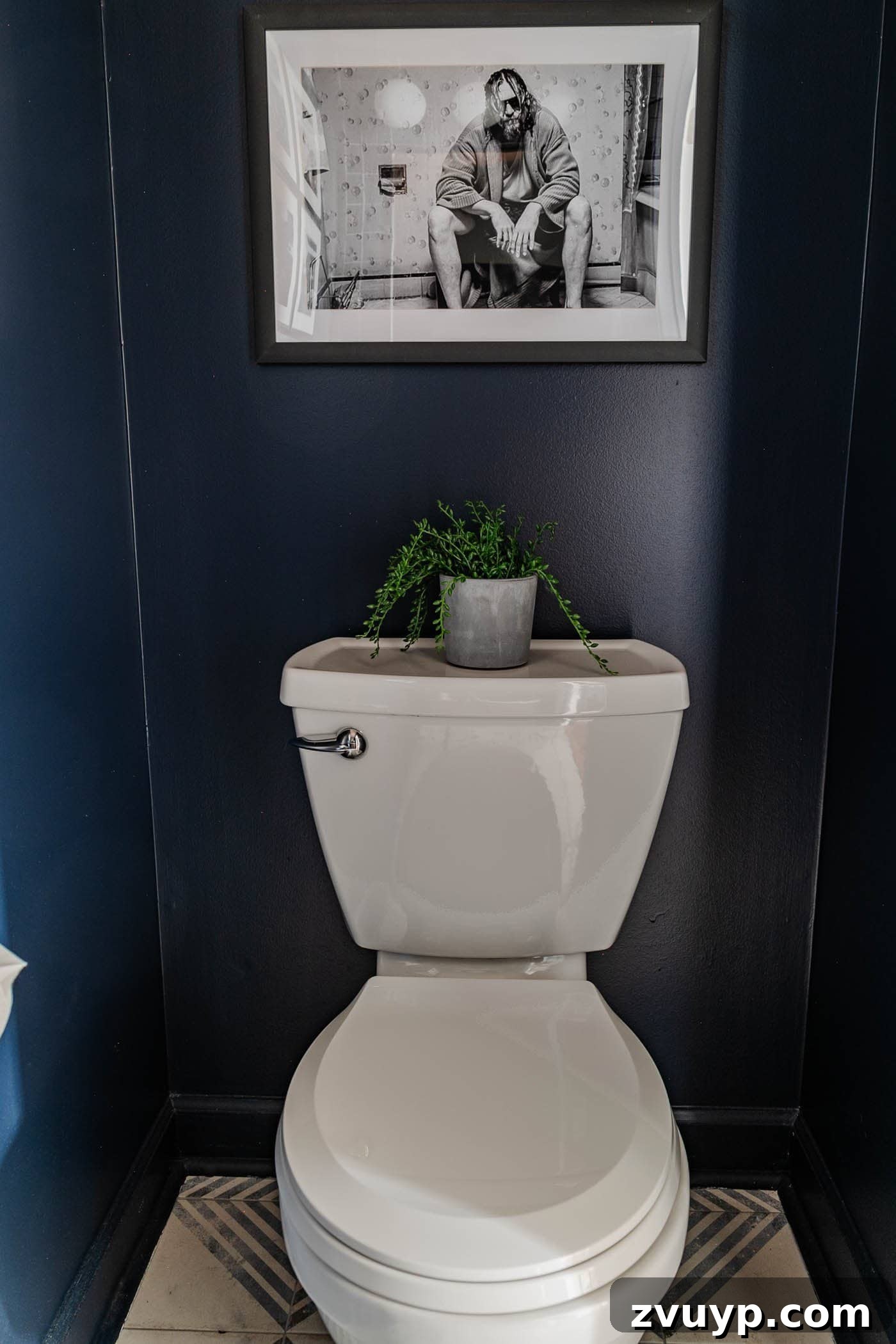 Sleek & Compact: Bachelor Pad Powder Room Makeover 11 navy blue small powder room with The Big Lebowski art above toilet, adding a touch of humor and personality