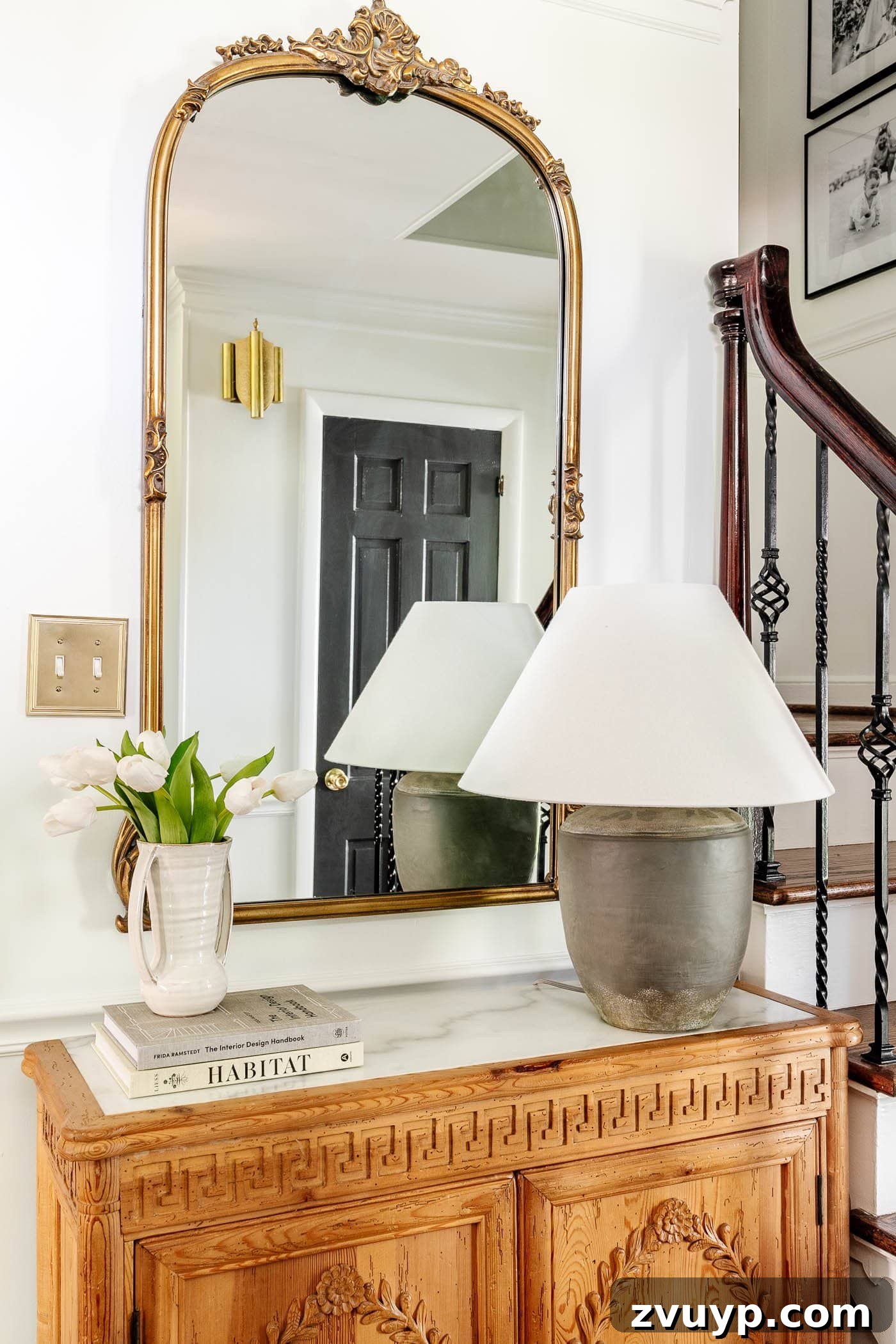 Pro Entry Table Styling: Your Step-by-Step Guide to a Stunning Entryway 7 adding a stack of books underneath a vase of flowers as risers for height in decorating a foyer table