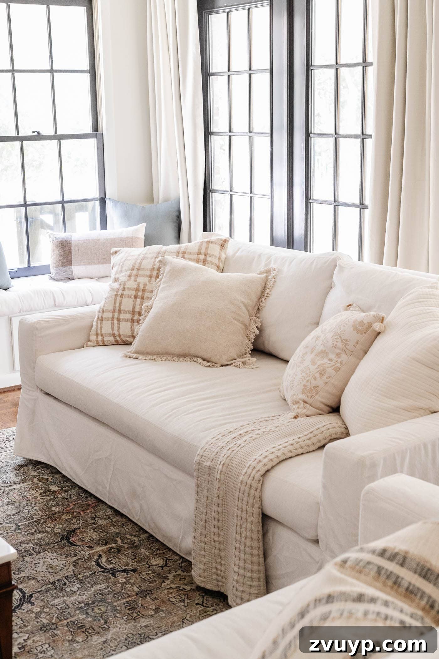 Faux Luxury Home Style for Less 22 white Pottery Barn York sofa in a living room with black French doors and linen curtains
