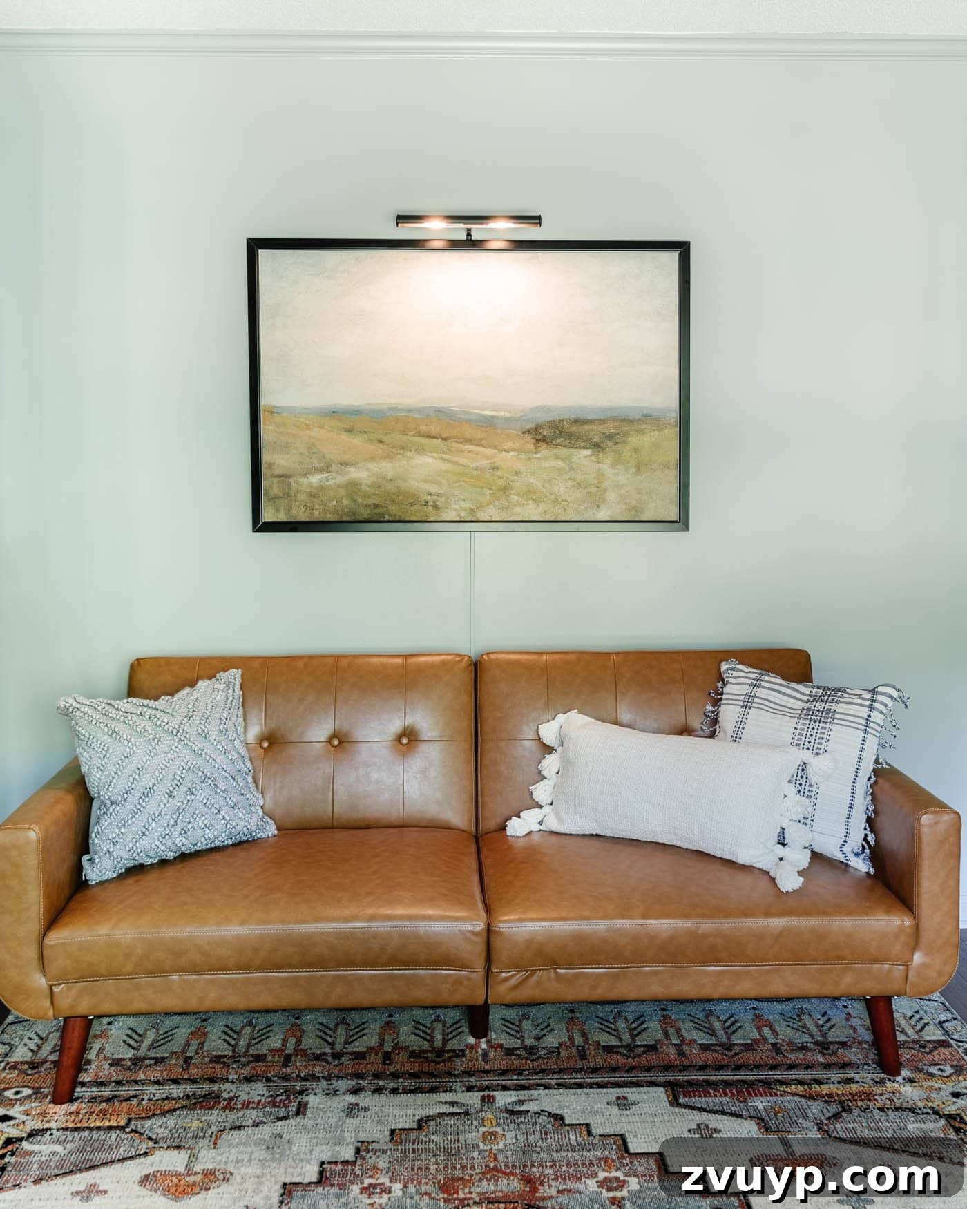 8 Productive Retreats: Design Your Home Office Lounge for Focus and Flow 10 Completed office lounge area with a faux leather futon, elegant wall art, and a sophisticated picture light, creating a refined atmosphere