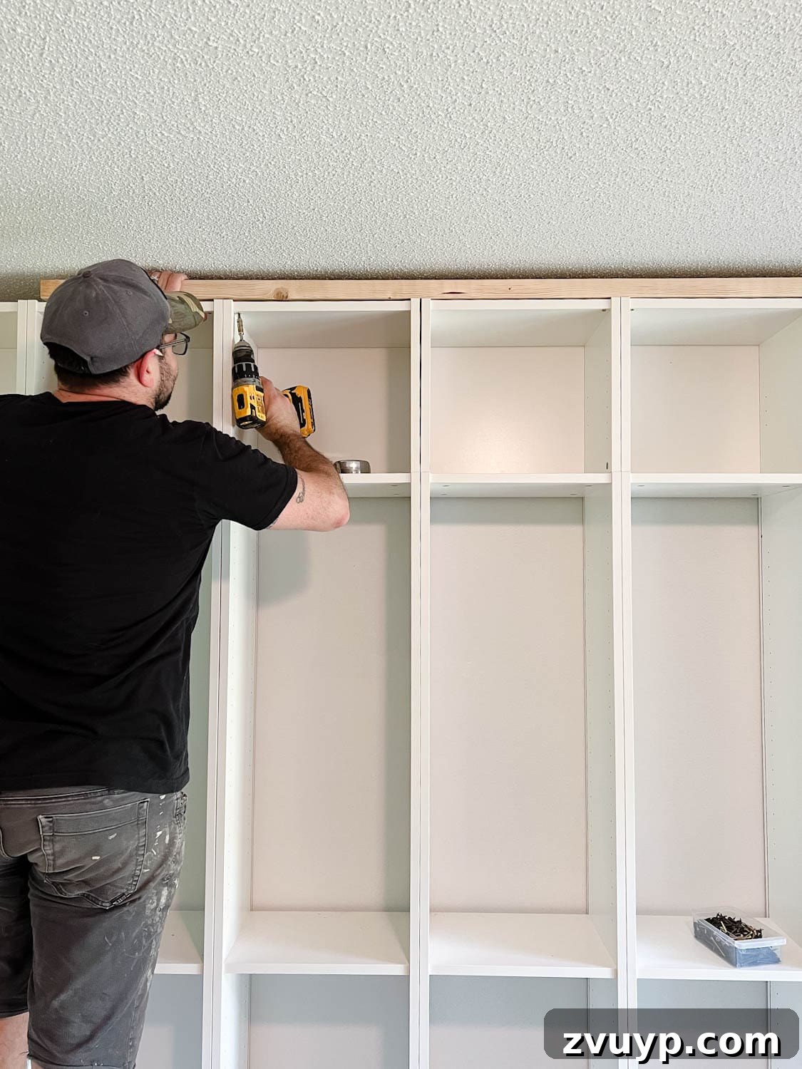 The IKEA Billy Hack: Custom Built-In Bookshelves Made Easy 14 adding a 2x4 board to the top of bookcases to fill the gap below the ceiling for DIY built in bookshelves