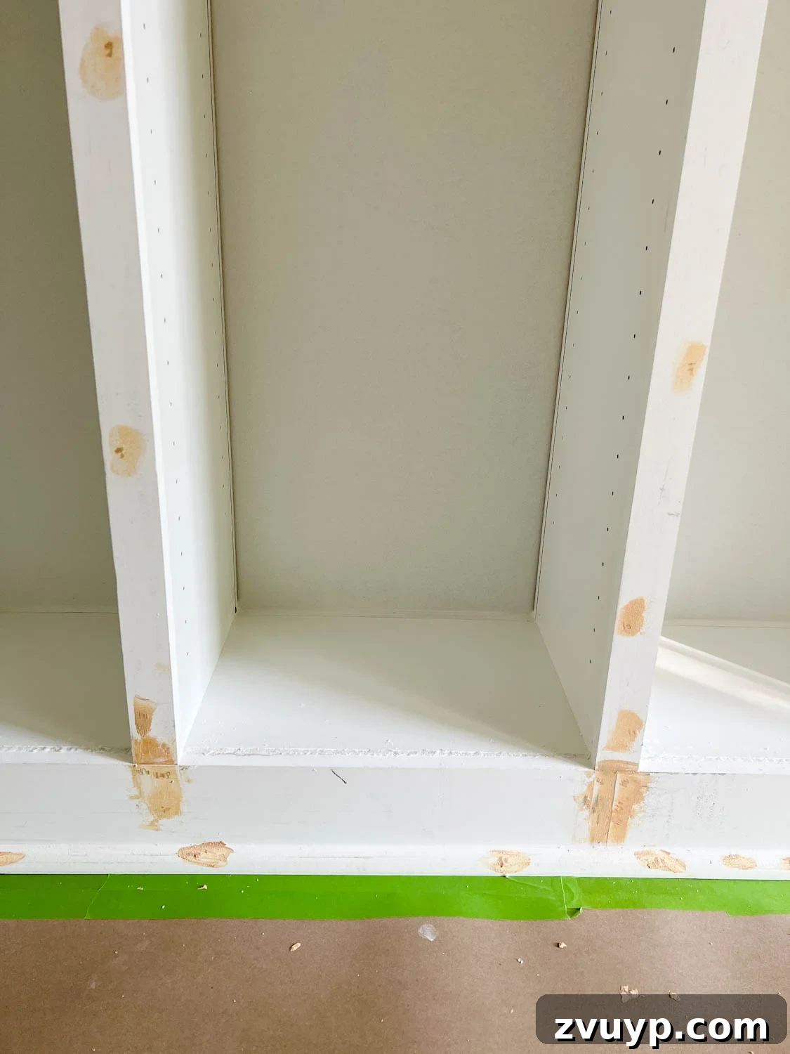 The IKEA Billy Hack: Custom Built-In Bookshelves Made Easy 23 wood filler, caulk, and Loctite foam covering gaps, cracks, and nail holes