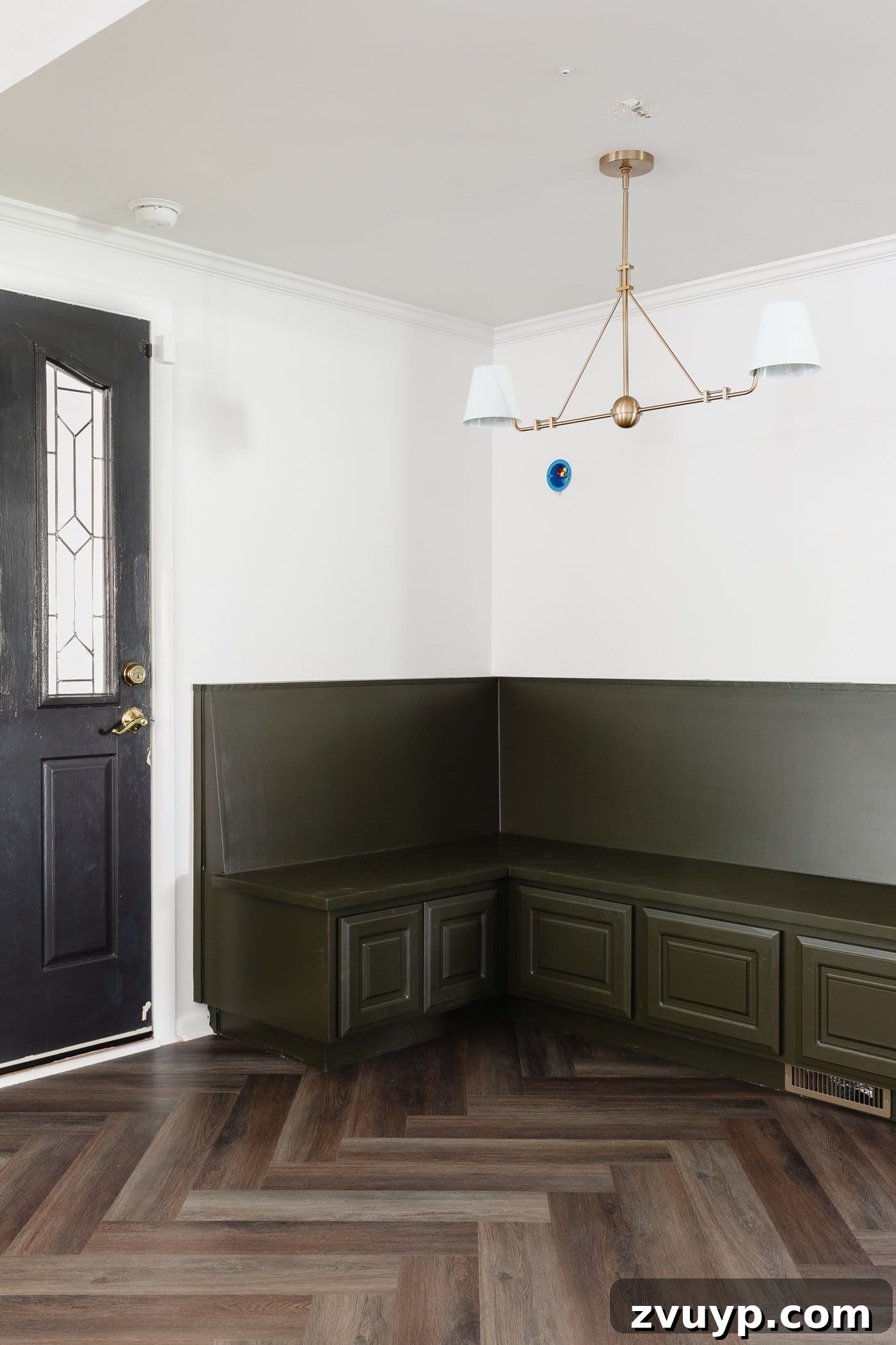 Elegant Banquette Seating That Won't Break the Bank 2 Breakfast nook banquette painted olive green with shaded linear chandelier and herringbone floors, showcasing cozy and space-saving dining