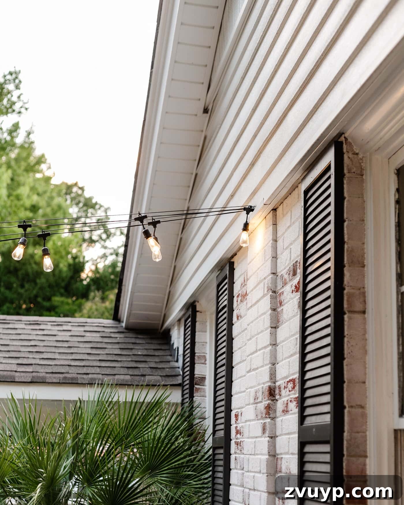 No Poles, No Problem: Creative Ways to Hang Backyard String Lights 4 string lights hanging from a hook on the side of a brick house