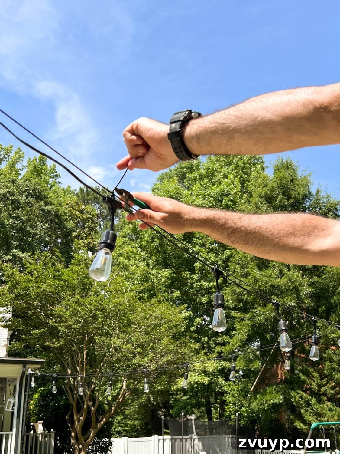No Poles, No Problem: Creative Ways to Hang Backyard String Lights 44 snipping zip tie ends to attach string lights to cable