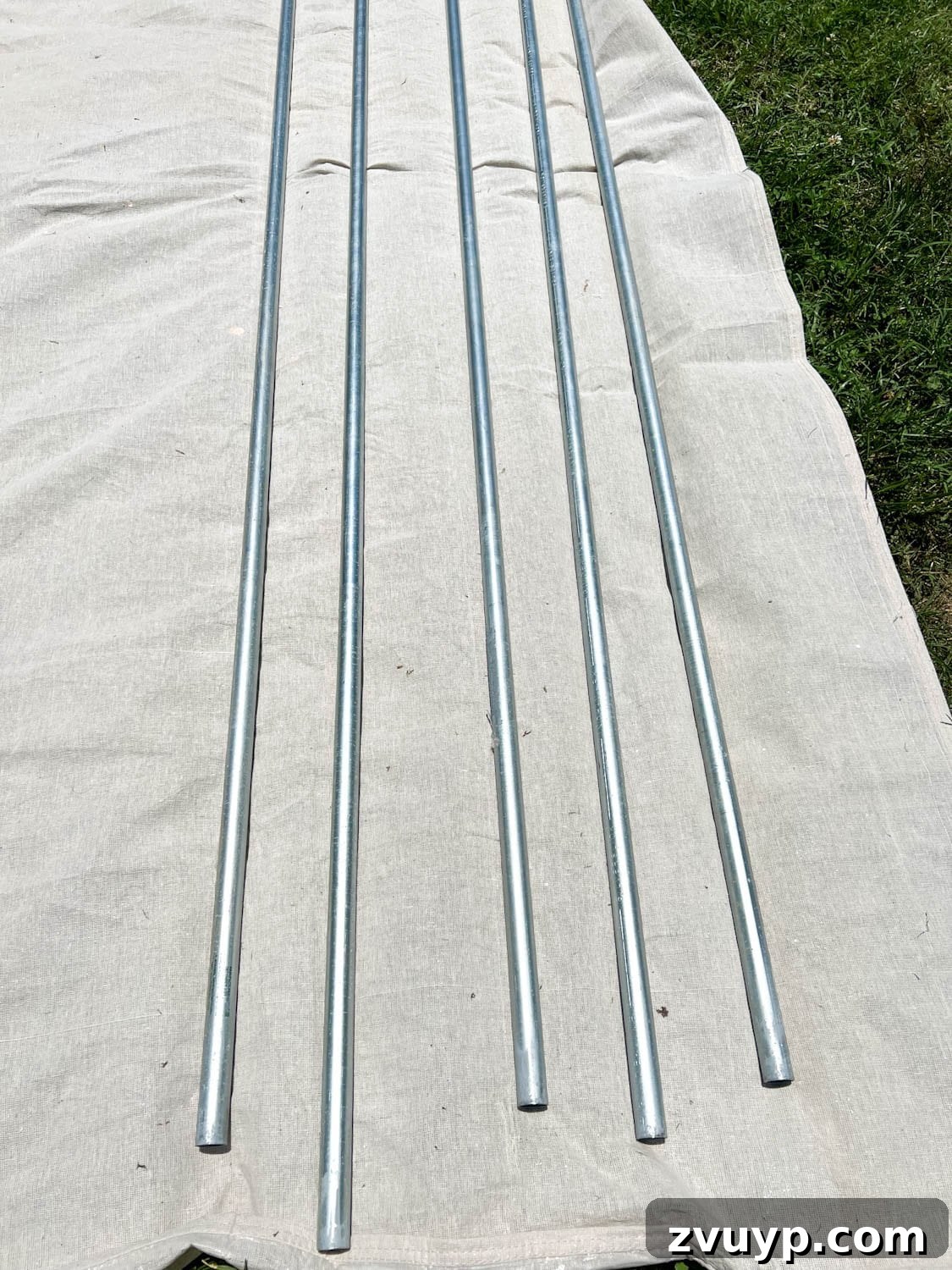 No Poles, No Problem: Creative Ways to Hang Backyard String Lights 10 conduit poles on a drop cloth ready to be painted