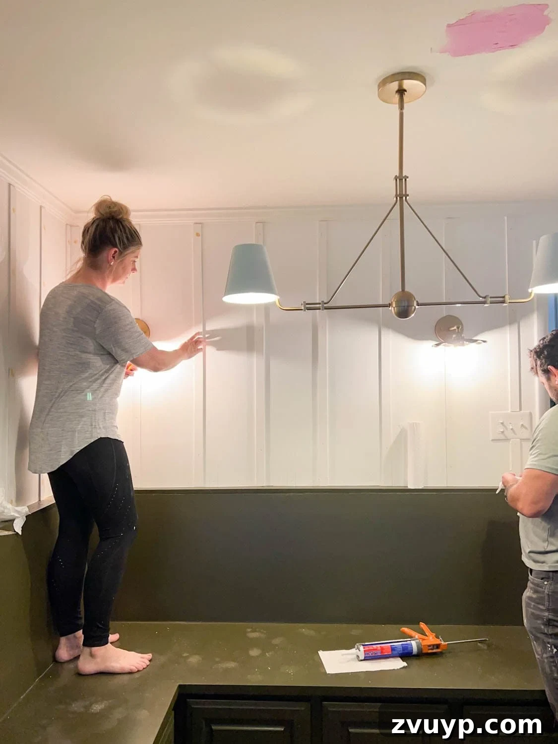 DIY Batten Wall Hack: Lattice Strips for an Affordable Look 9 A detailed shot showing the meticulous process of caulking and wood filling lattice strips on a wall, ensuring a smooth and flawless surface in preparation for painting.