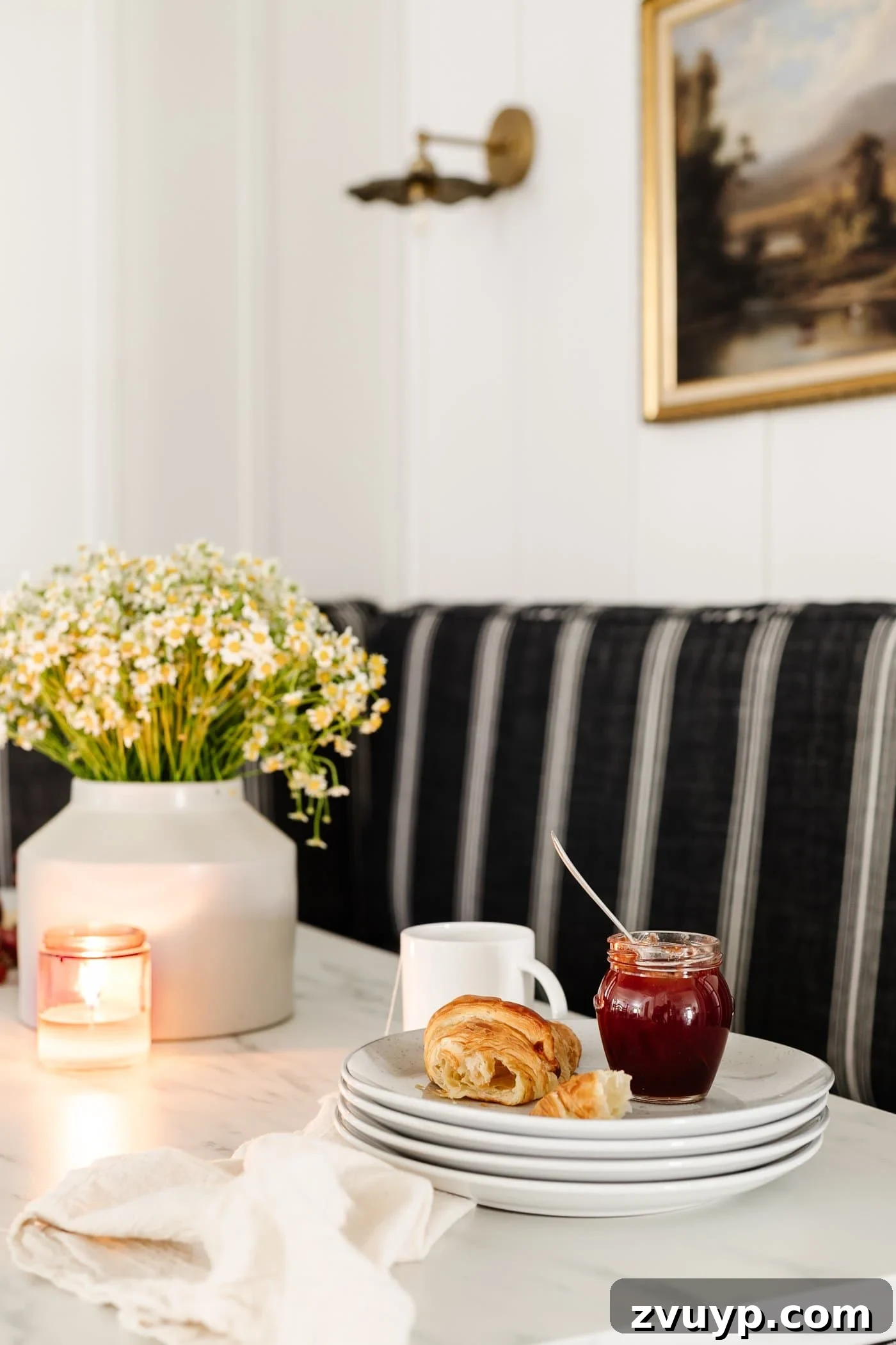 Corner Kitchen Refresh From Dated to Dazzling 16 breakfast table decor - vase of daisies, wood cutting board with croissants, bowl of grapes, and candle