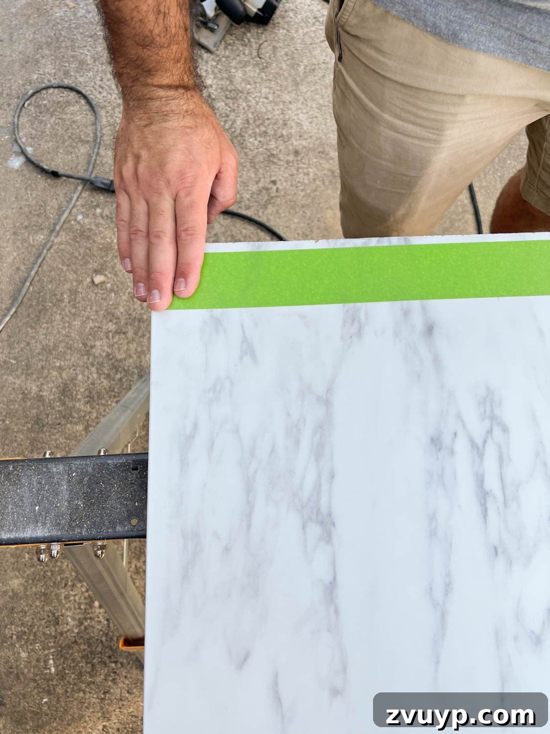 One Hour Faux Marble Dining Table Makeover 5 putting masking tape on laminate faux marble countertop to be cut