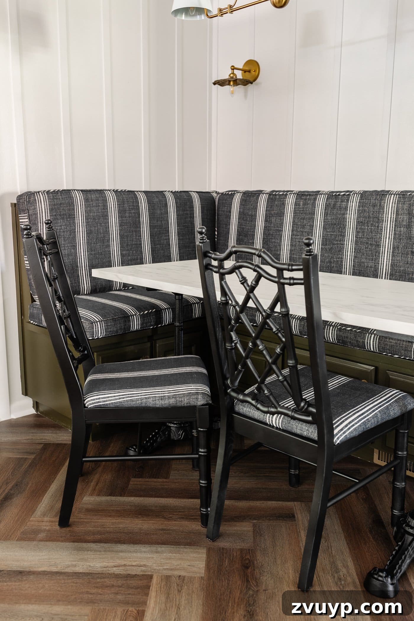 From Drab to Fab: DIY Dining Chair Reupholstery and Faux Bamboo Makeover 11 black bamboo chairs with striped upholstered seats in a breakfast nook with olive green banquette bench
