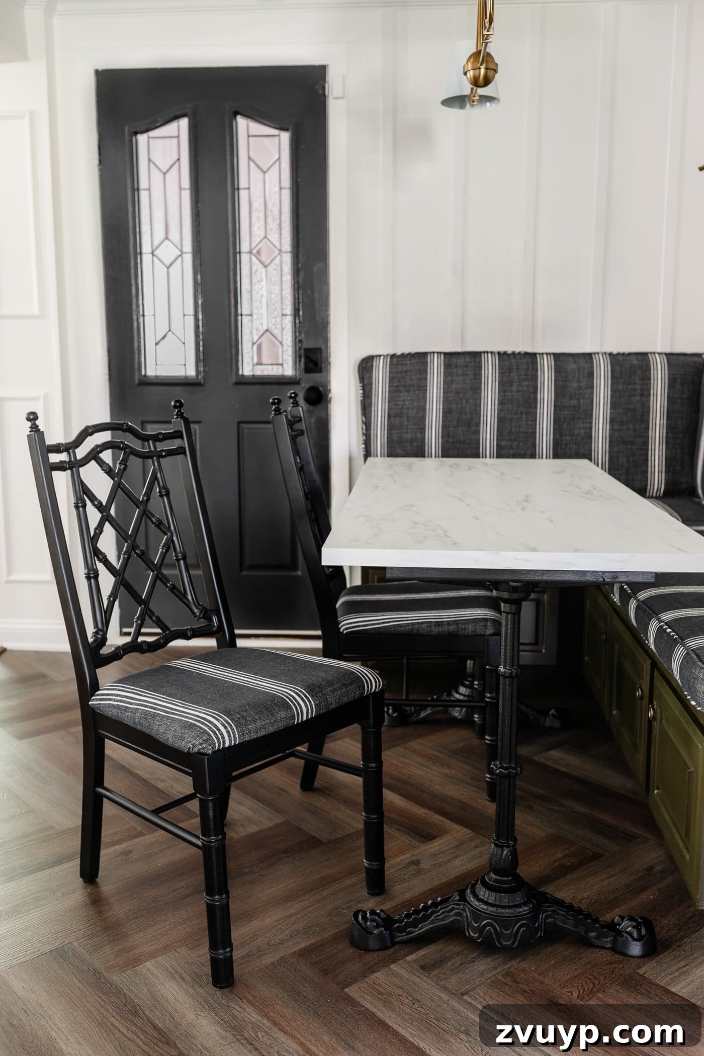From Drab to Fab: DIY Dining Chair Reupholstery and Faux Bamboo Makeover 13 black bamboo chairs with striped upholstered seats in a breakfast nook with olive green banquette bench