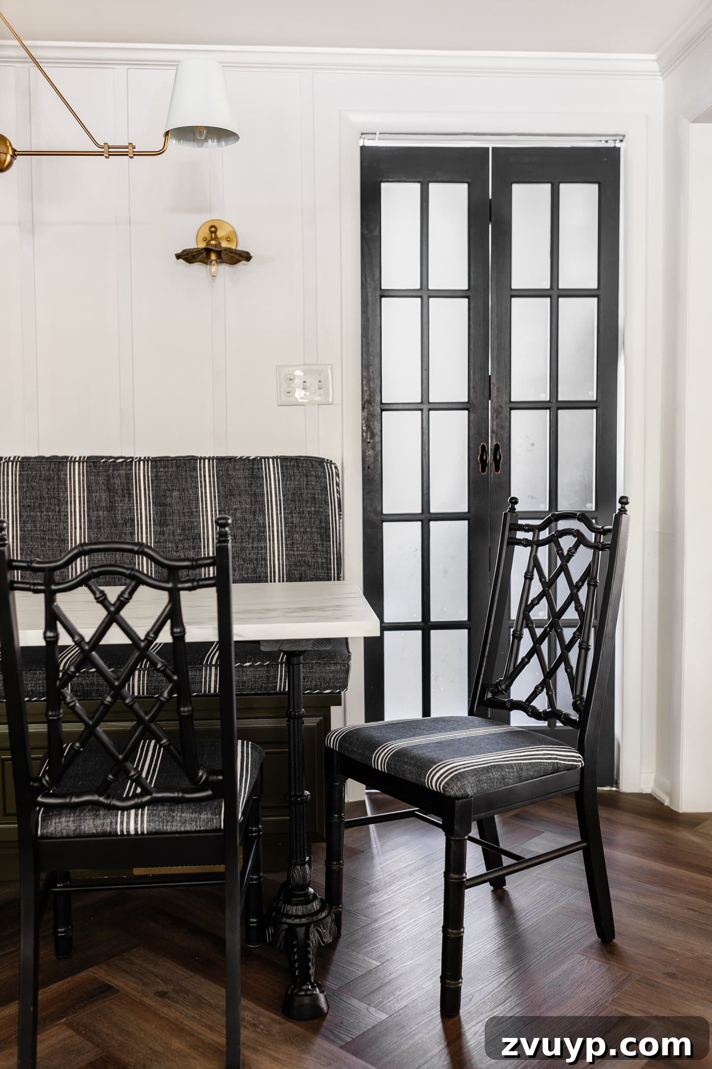 From Drab to Fab: DIY Dining Chair Reupholstery and Faux Bamboo Makeover 14 black bamboo chairs with striped upholstered seats in a breakfast nook with olive green banquette bench